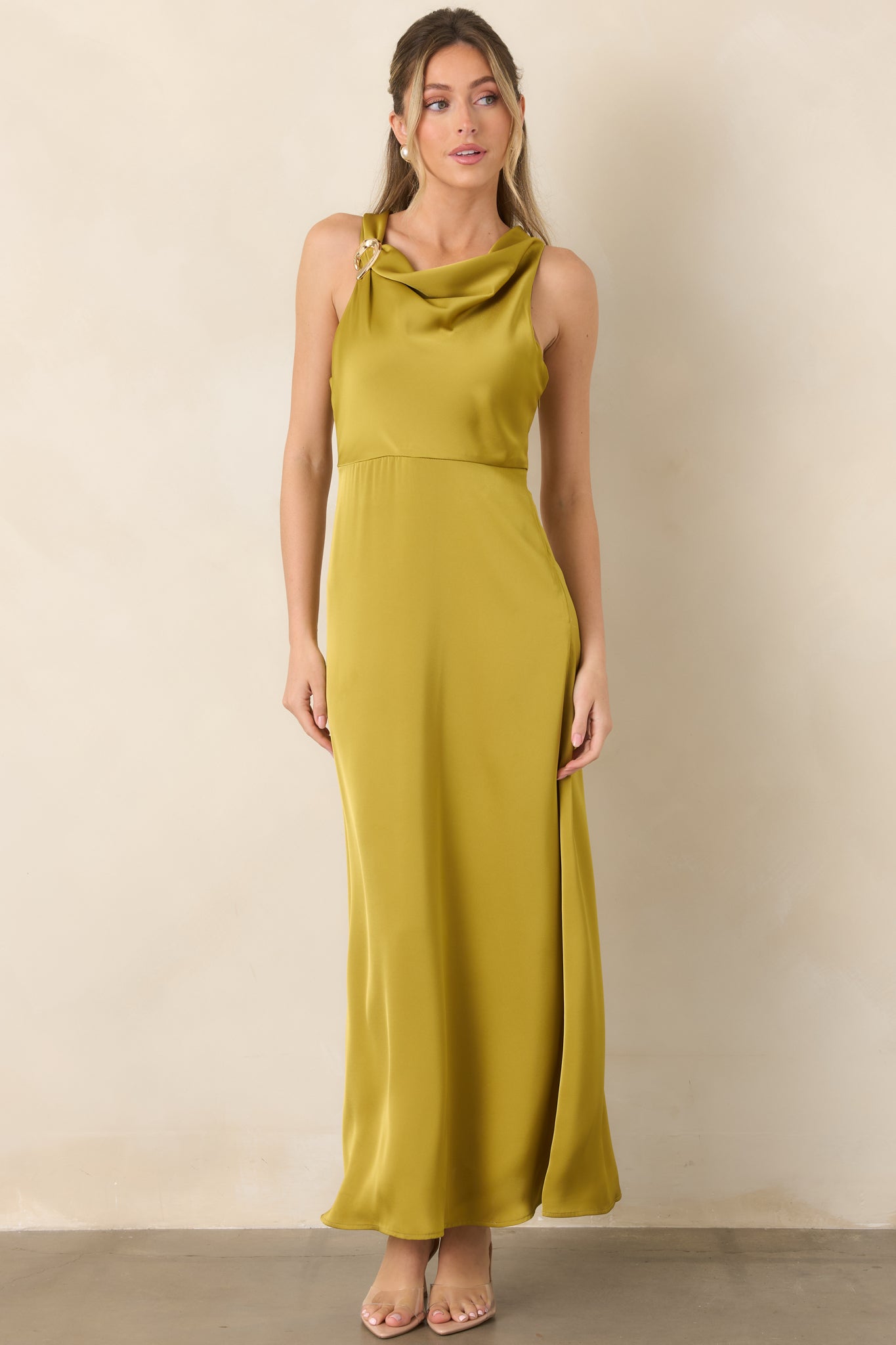 Elegant satin gown showcasing its fluid floor-length shape, gathered draped neckline, defined empire waist, and metallic shoulder detail.