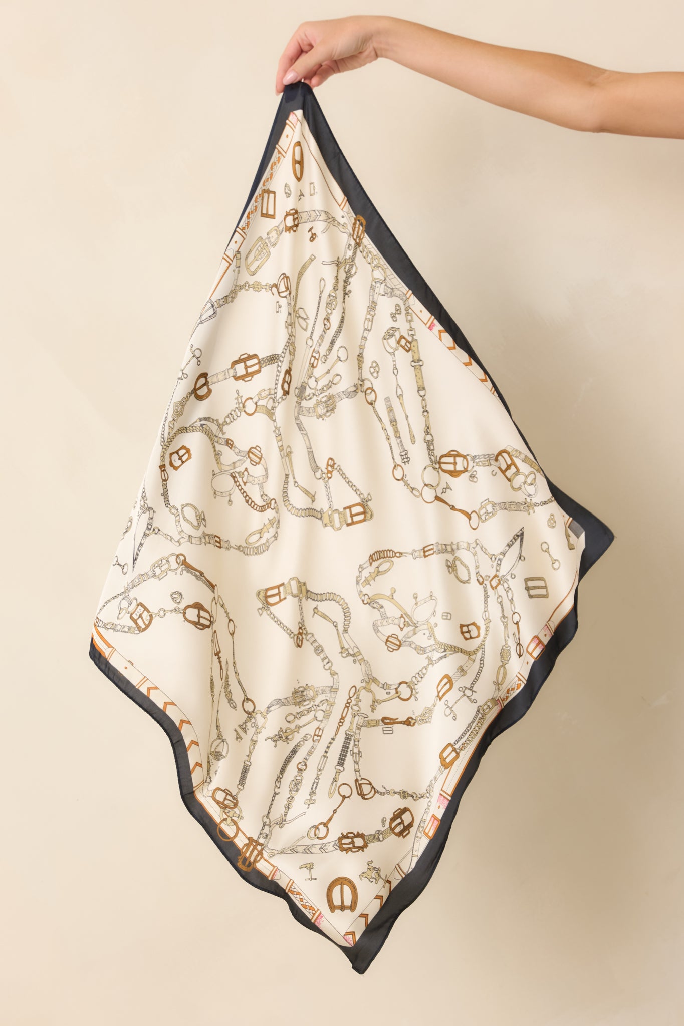 Satin hair scarf featuring an intricate vintage hardware print with chains, buckles, straps, and clasps in warm neutral tones.