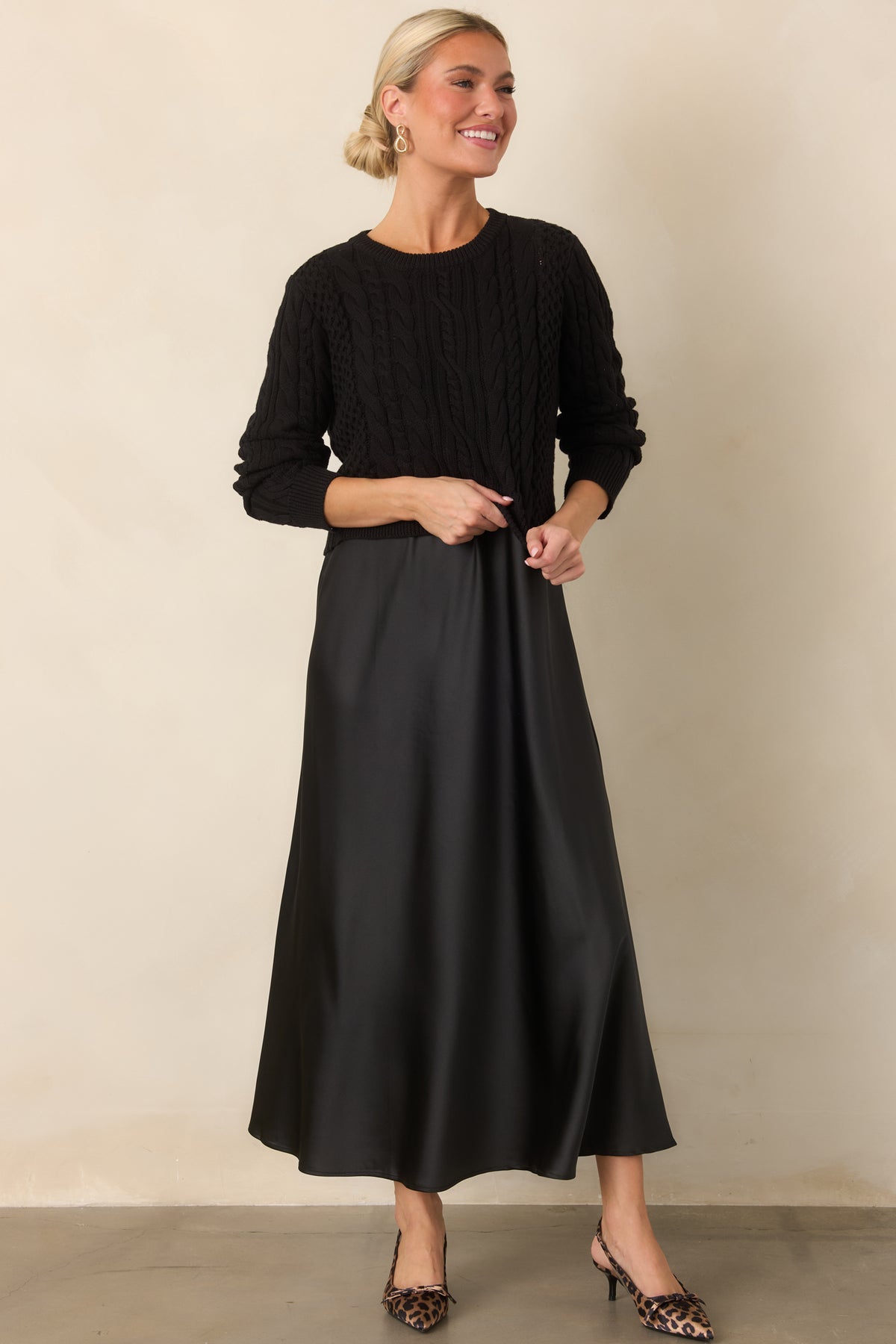 The satin maxi dress falls in a smooth, fluid line beneath the contrasting textured cropped sweater.