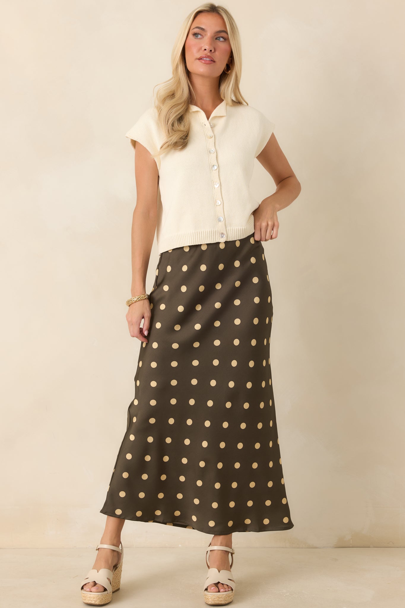 Satin midi skirt showcasing a vintage-inspired cream polka dot print, flowing bias cut, and comfortable elastic waistband.