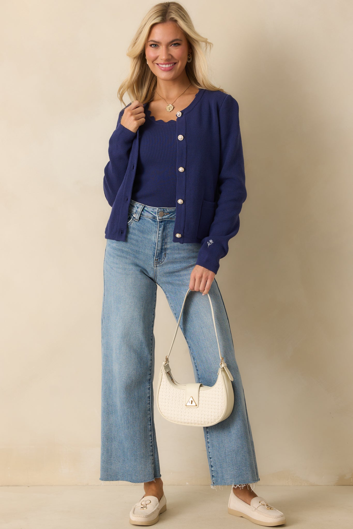 Classic long sleeve cardigan showcasing scalloped neckline detailing and elegant pearl-inspired buttons with gold-tone accents.