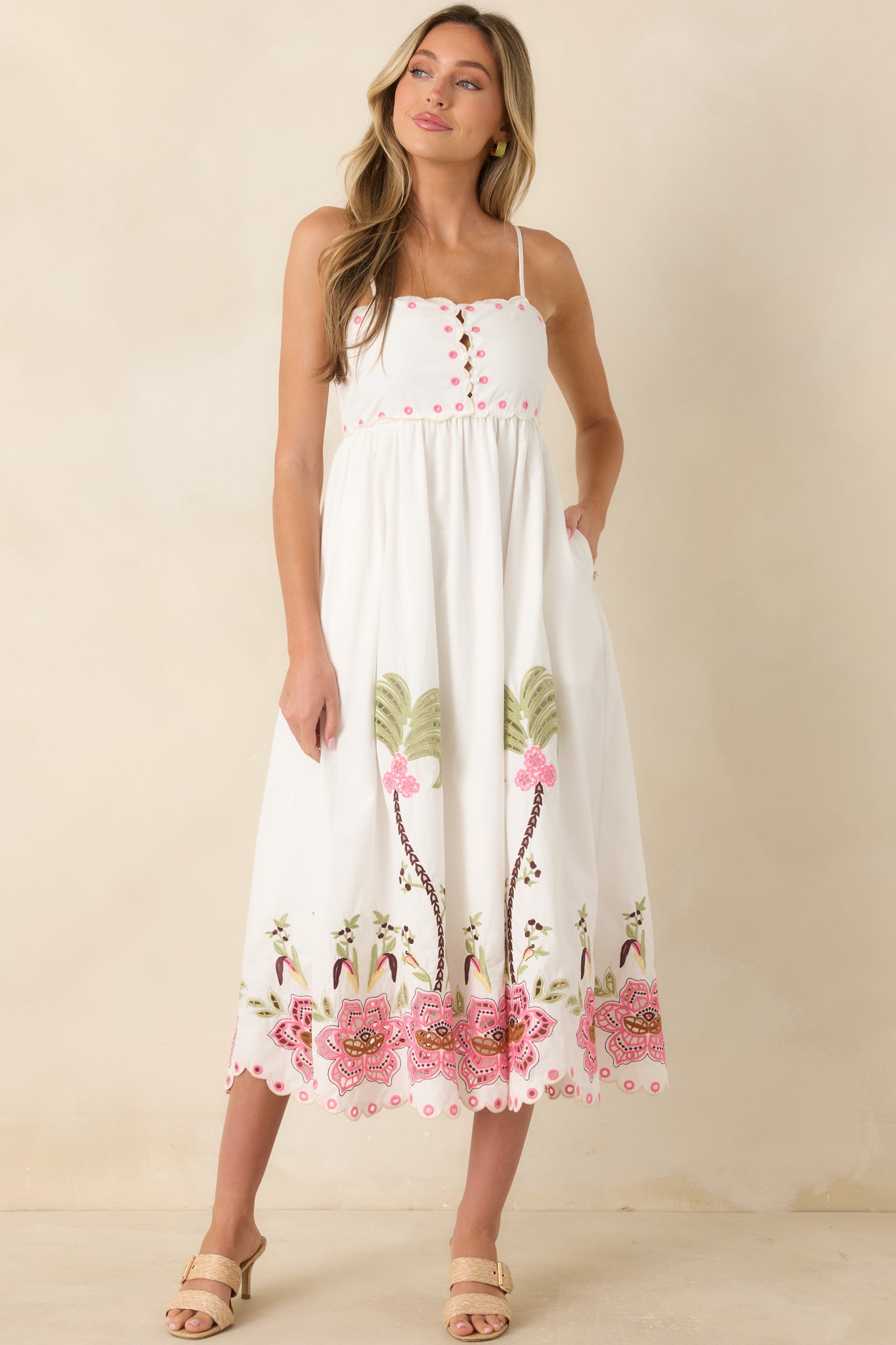 Elegant embroidered midi dress with a fitted bodice, flowing A-line silhouette, scalloped details, and a decorative cutwork border.