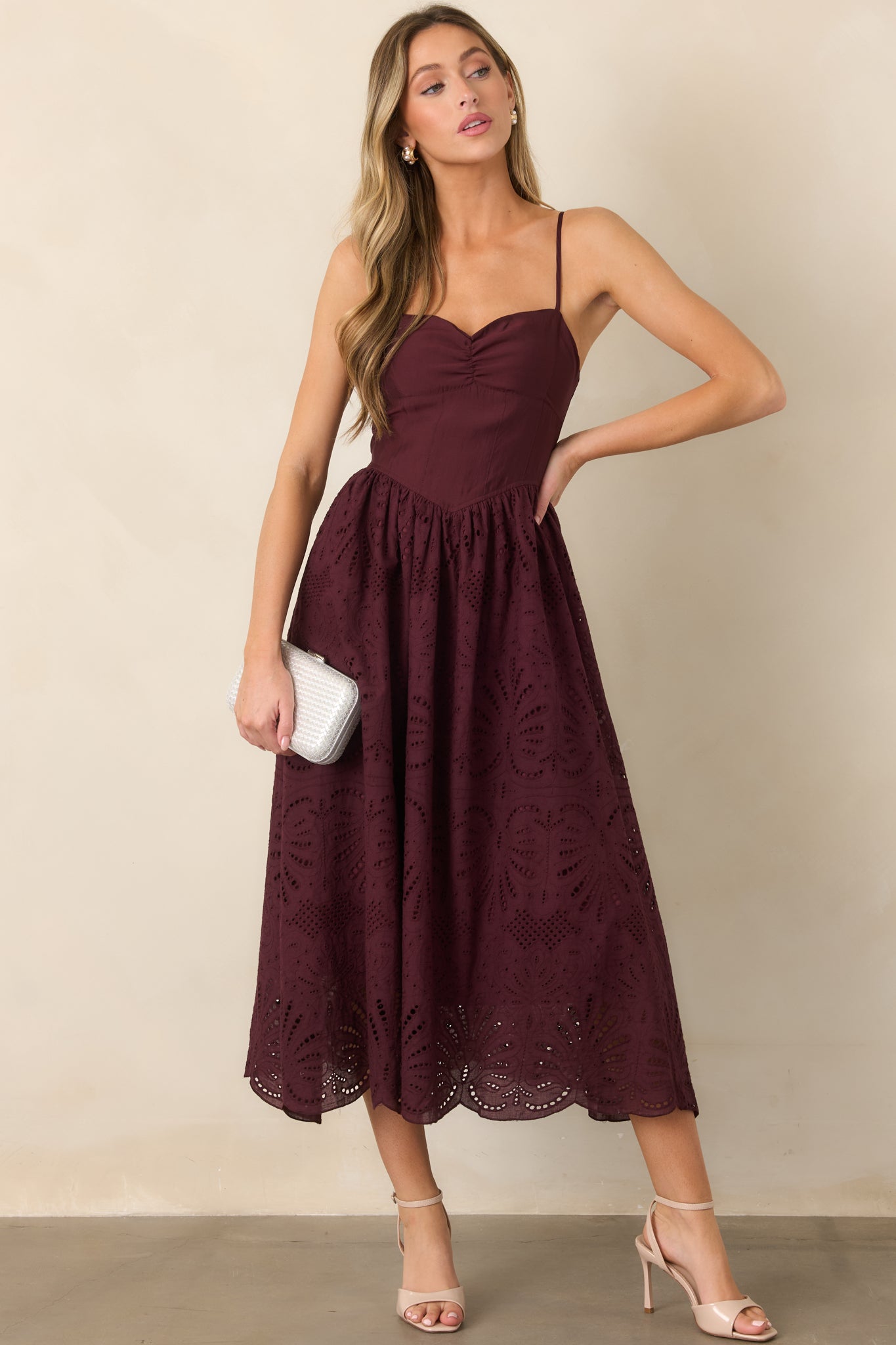 Feminine eyelet dress with a sculpted sweetheart neckline, softly gathered skirt, flared shape, and scalloped edging along the hem.