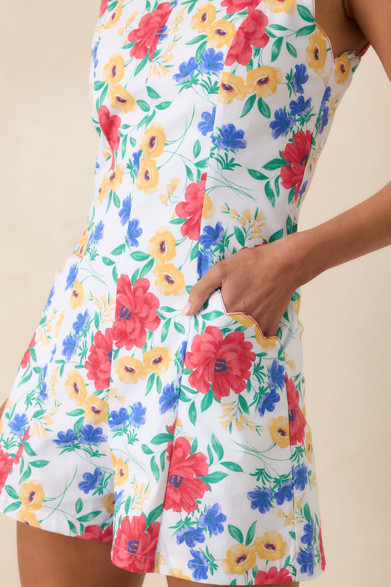 Scalloped pocket edge detail on vibrant floral romper.