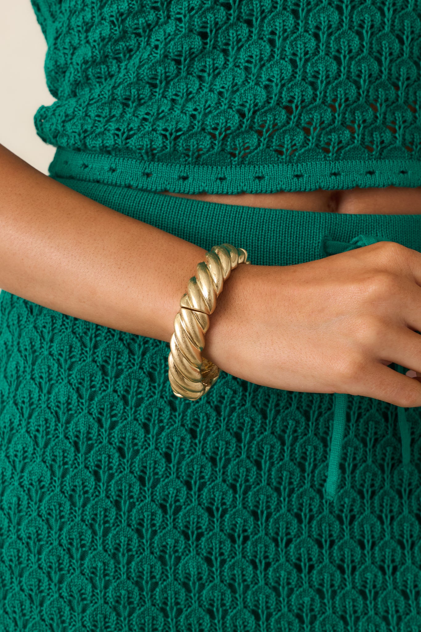 Sculptural gold bracelet with textured twist detailing and a comfortable stretch fit for an elevated look.