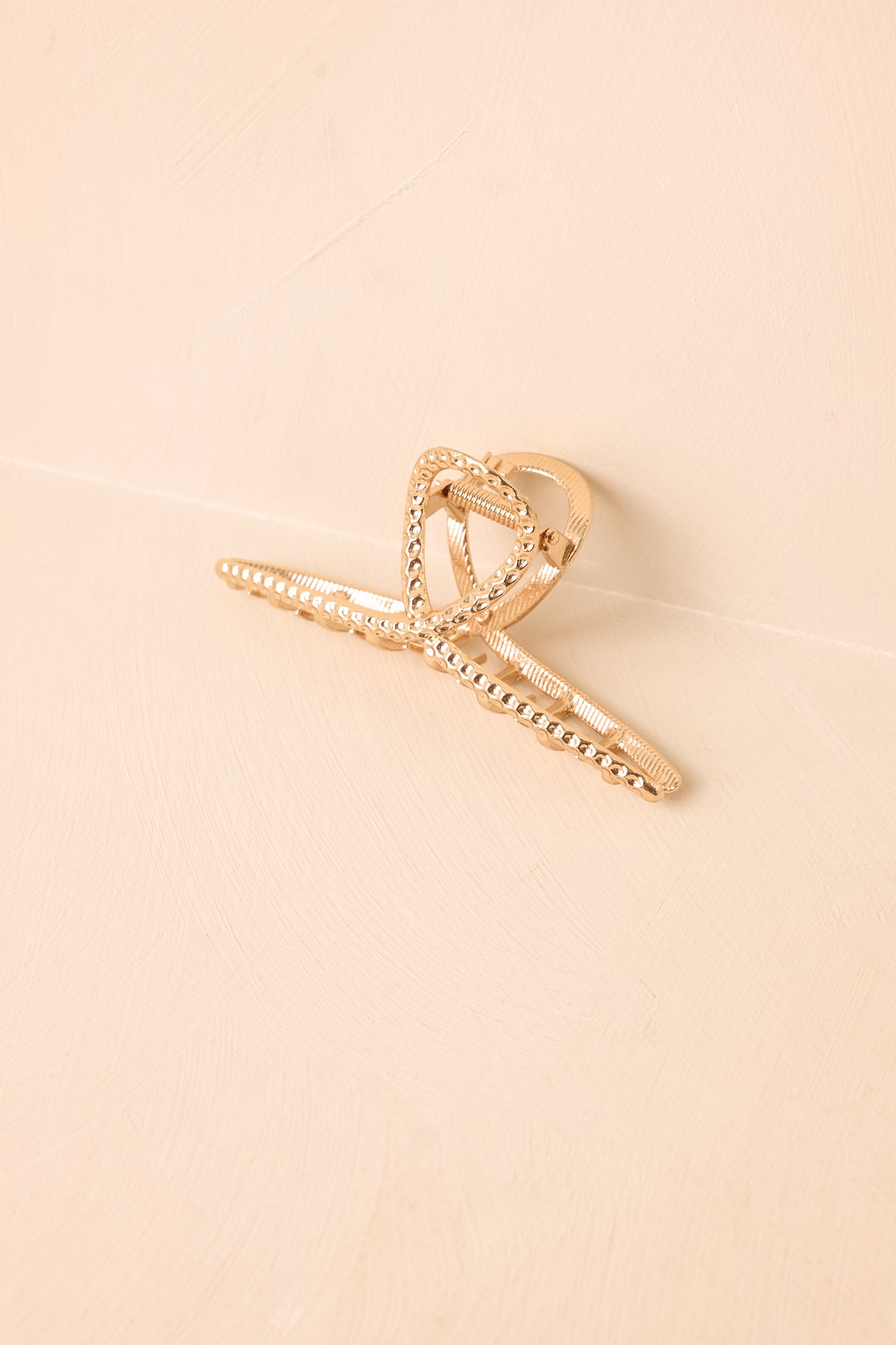 Sculptural hair claw clip showcasing a lightly textured finish, rounded open structure, and sturdy grip for versatile styling.