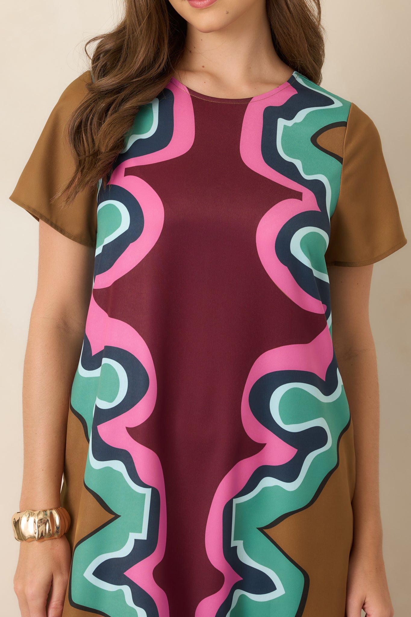 Close-up of the maxi dress highlighting the intricate serpentine pattern and its burgundy, camel, seafoam green, navy, light blue, and pink color combination.