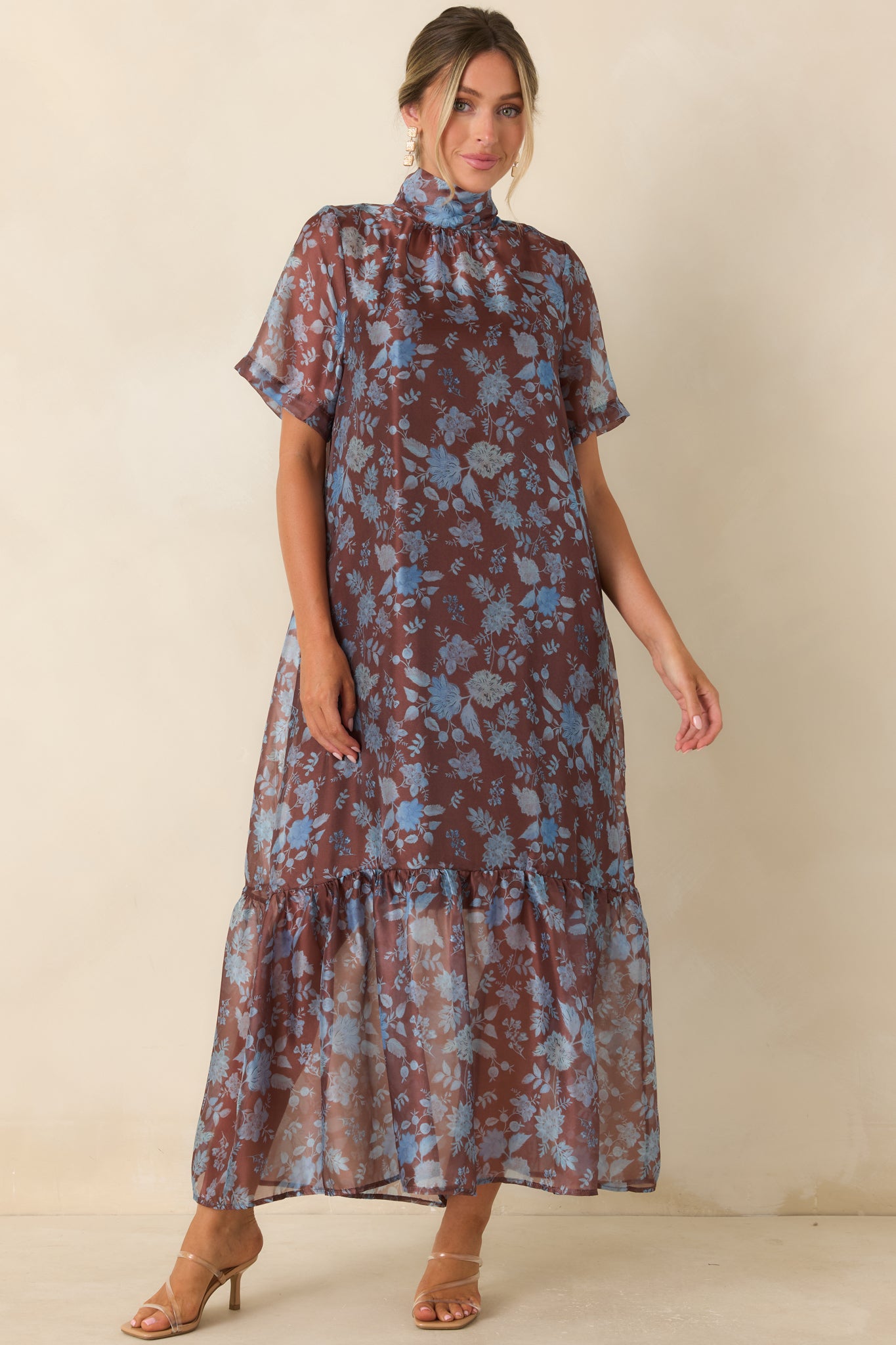 Sheer overlay dress featuring a tied mock neckline, flowing skirt layers, and a romantic floral pattern.