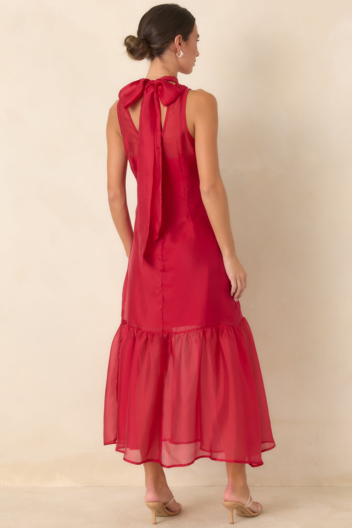 Rear of the sheer organza maxi dress showing the dramatic back tie, keyhole opening, and concealed zipper.