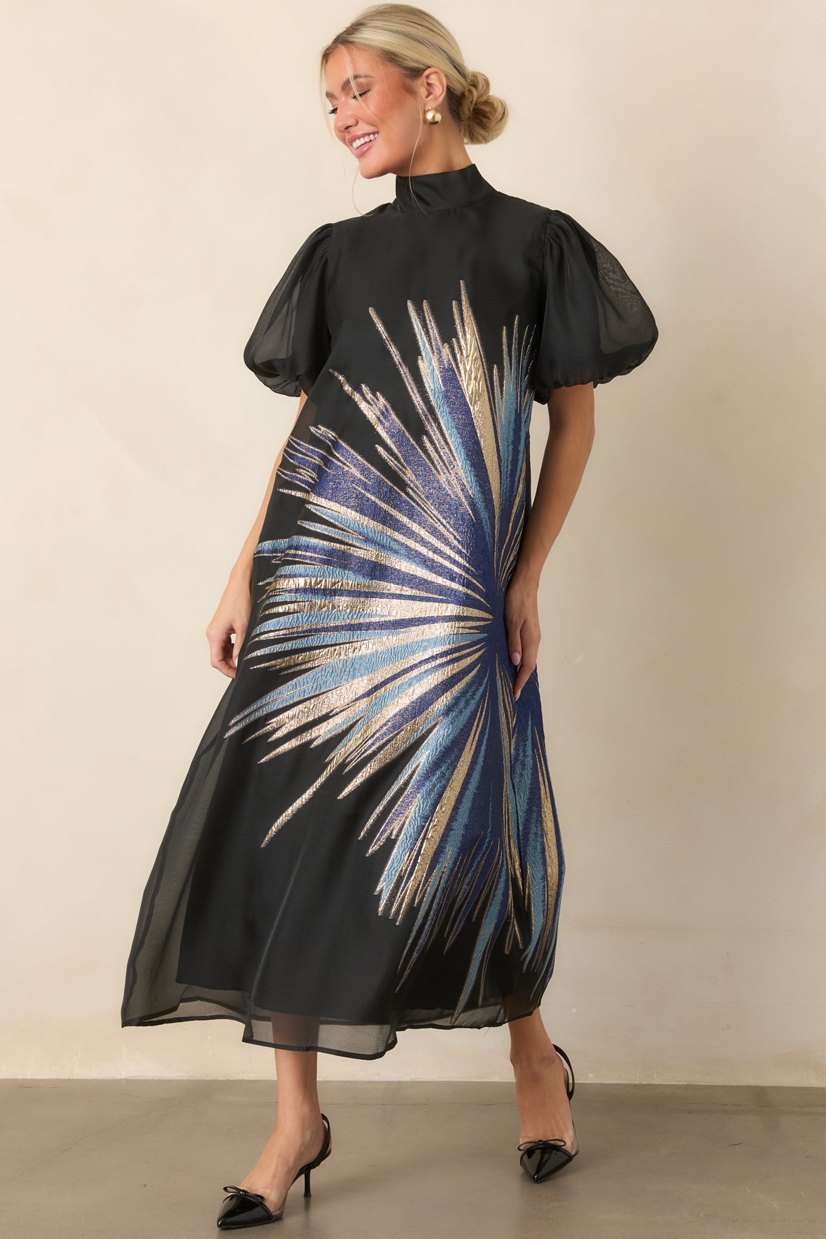 Sheer overlay dress with shimmering metallic starburst detailing, a high neckline, and flowing midi-length skirt.