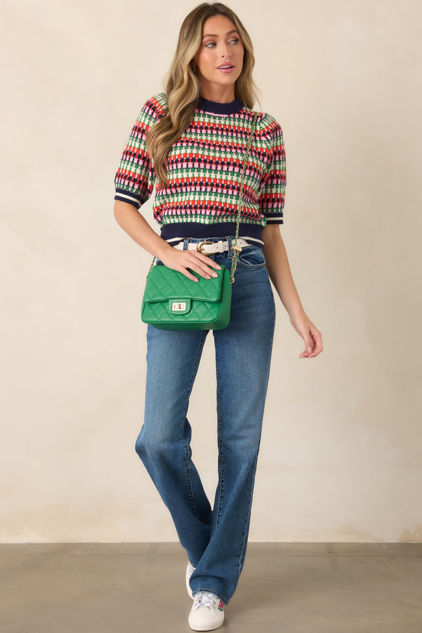 Short-sleeve striped sweater with a crew neckline and navy ribbed trim, featuring a vibrant mix of multicolor stripes throughout.