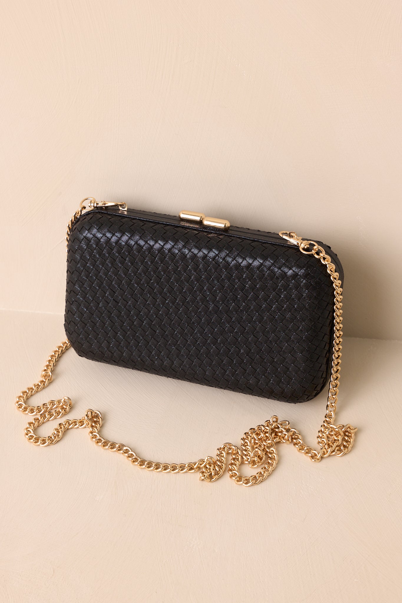 A cropped shot highlighting the woven design, structured rectangular silhouette, and optional gold chain.