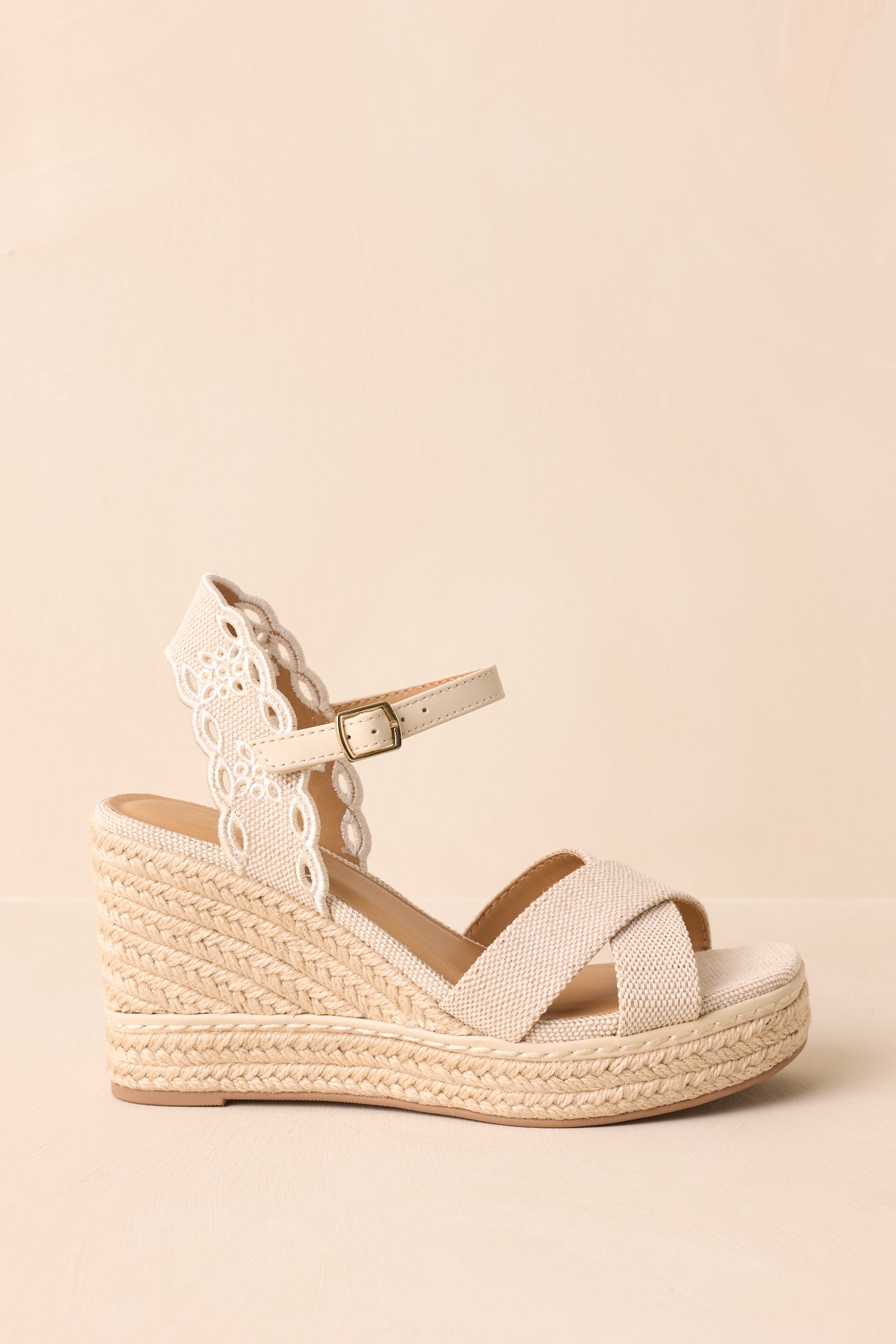 A focused shot of the adjustable ankle strap with silver buckle, attached to the embroidered heel strap.