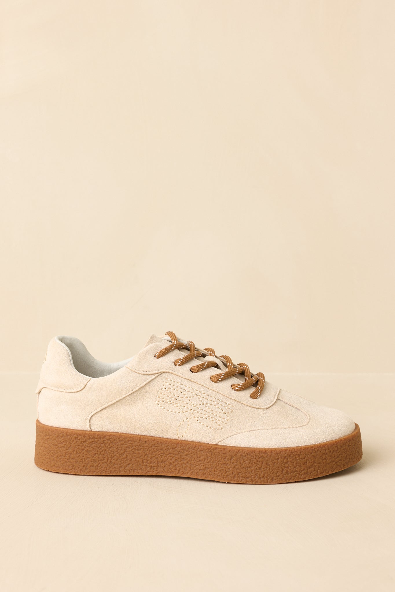 Side angle showing tonal decorative stitching, textured rubber platform sole, and low-profile silhouette.