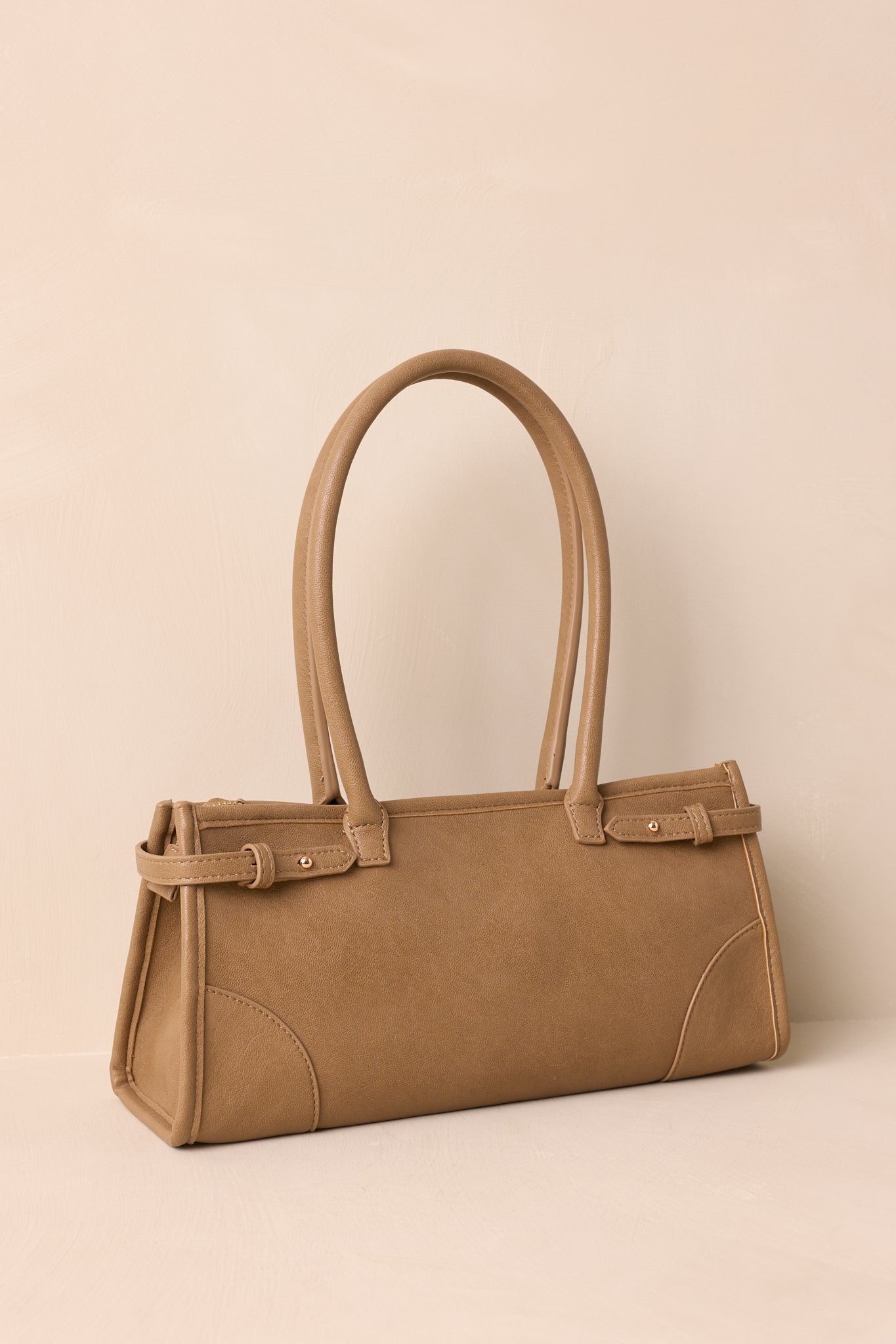 Side angle of the handbag highlighting the structured shape, top zip closure, and optional crossbody strap attachment.