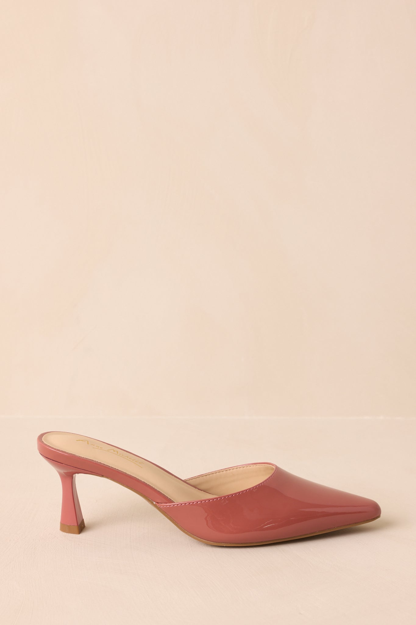 A side cropped angle of the mules showing the slip-on silhouette and flared kitten heel.