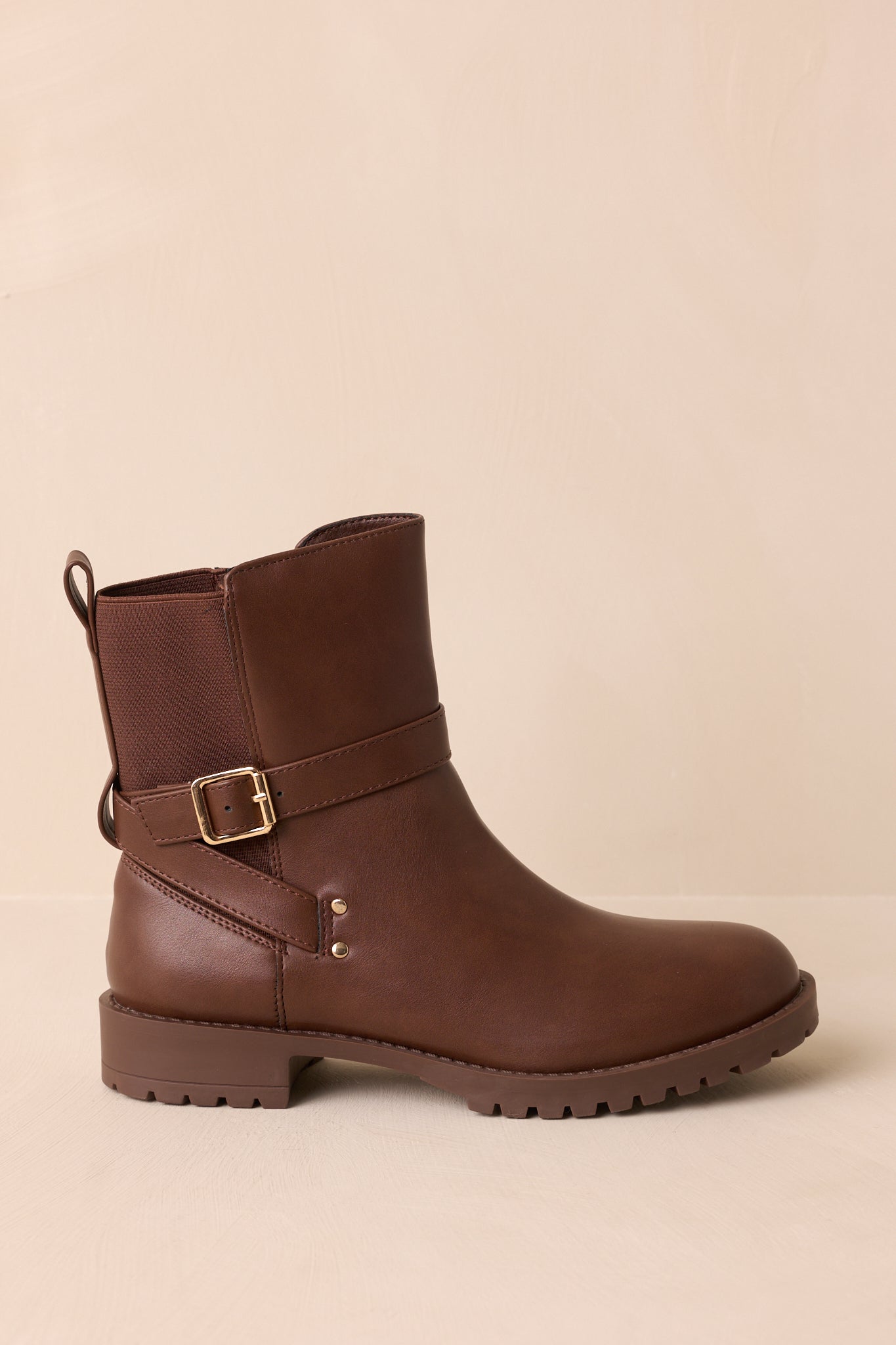A side cropped view highlighting the wraparound strap with a gold-tone buckle on the ankle boots.