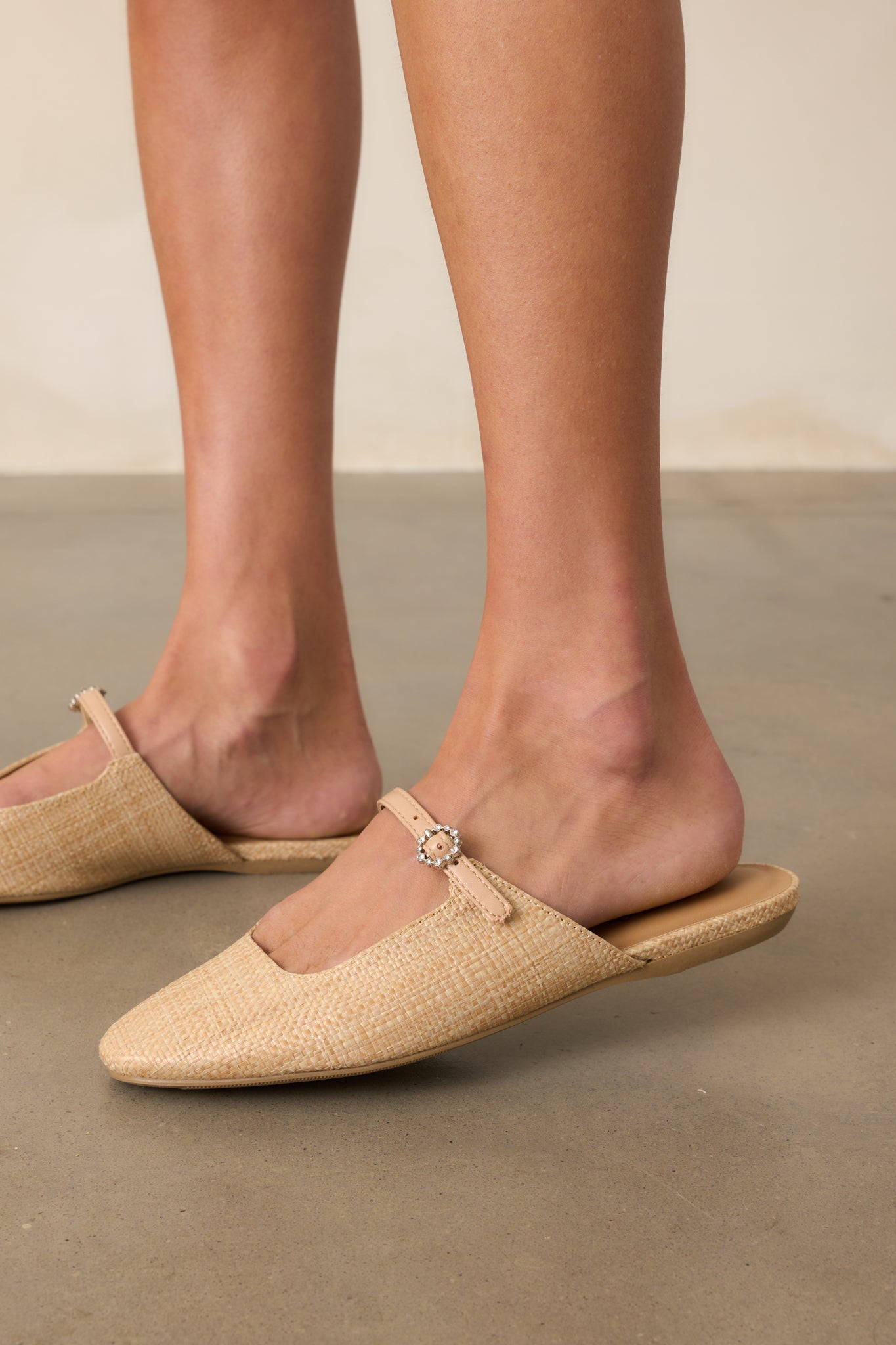 Side cropped view highlighting the slip-on mule structure and flat sole.