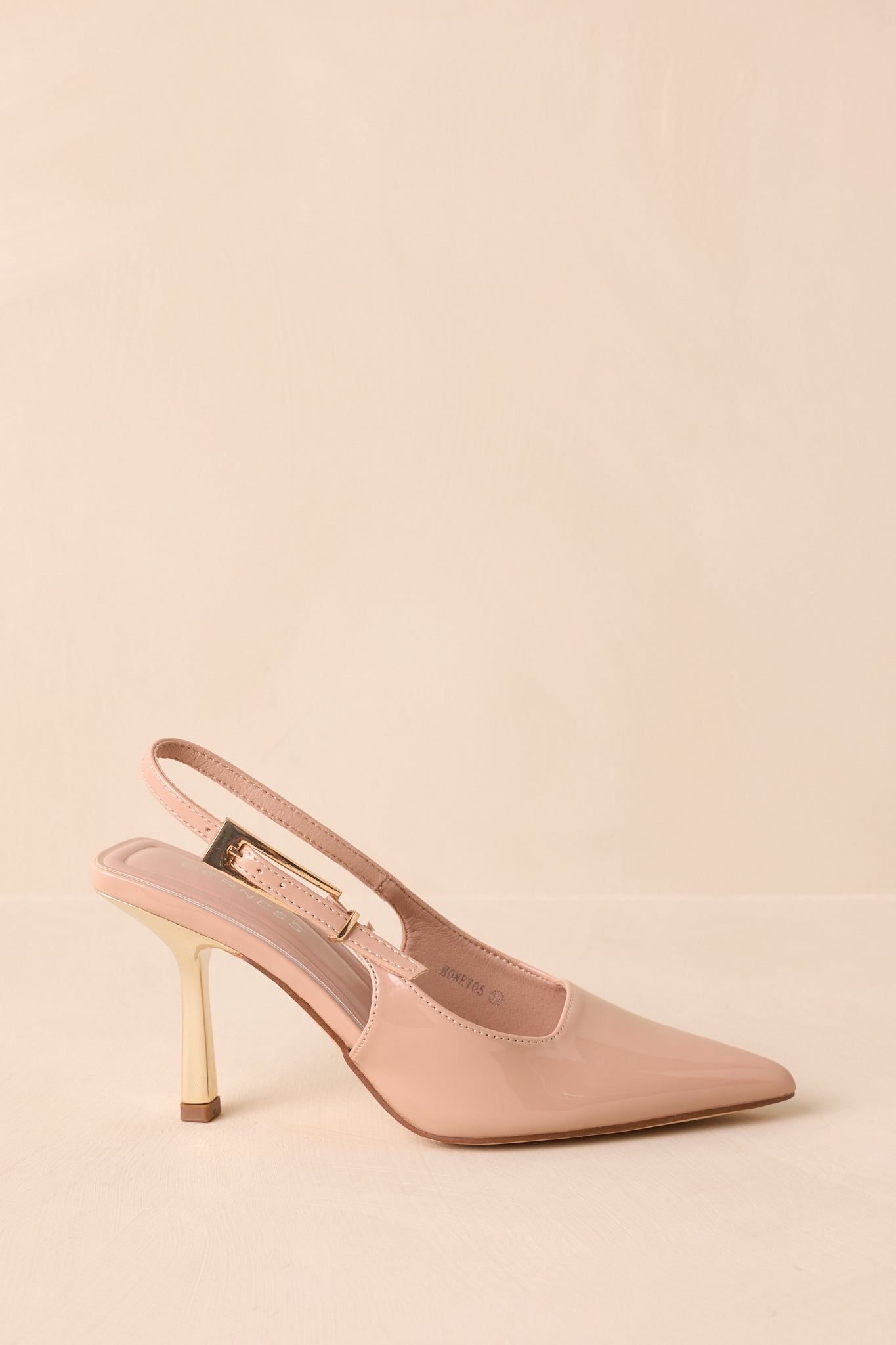 Side view of shiny beige heels featuring adjustable slingback strap and gold buckle.