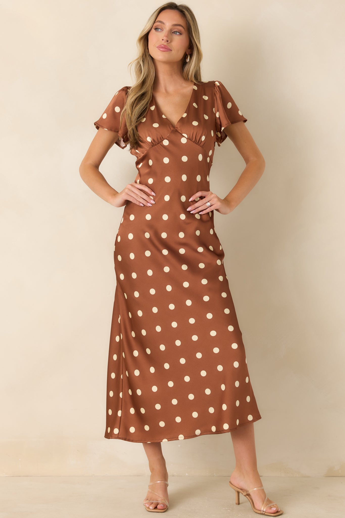 Silky satin midi dress designed with an empire waist, V-neckline, delicate sleeves, and graceful drape.