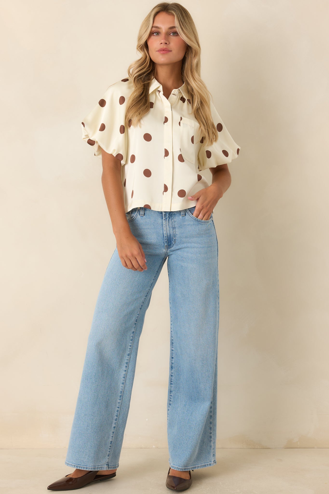 Silky woven blouse designed with voluminous puff sleeves, gathered shoulders, and a polished button-front silhouette.