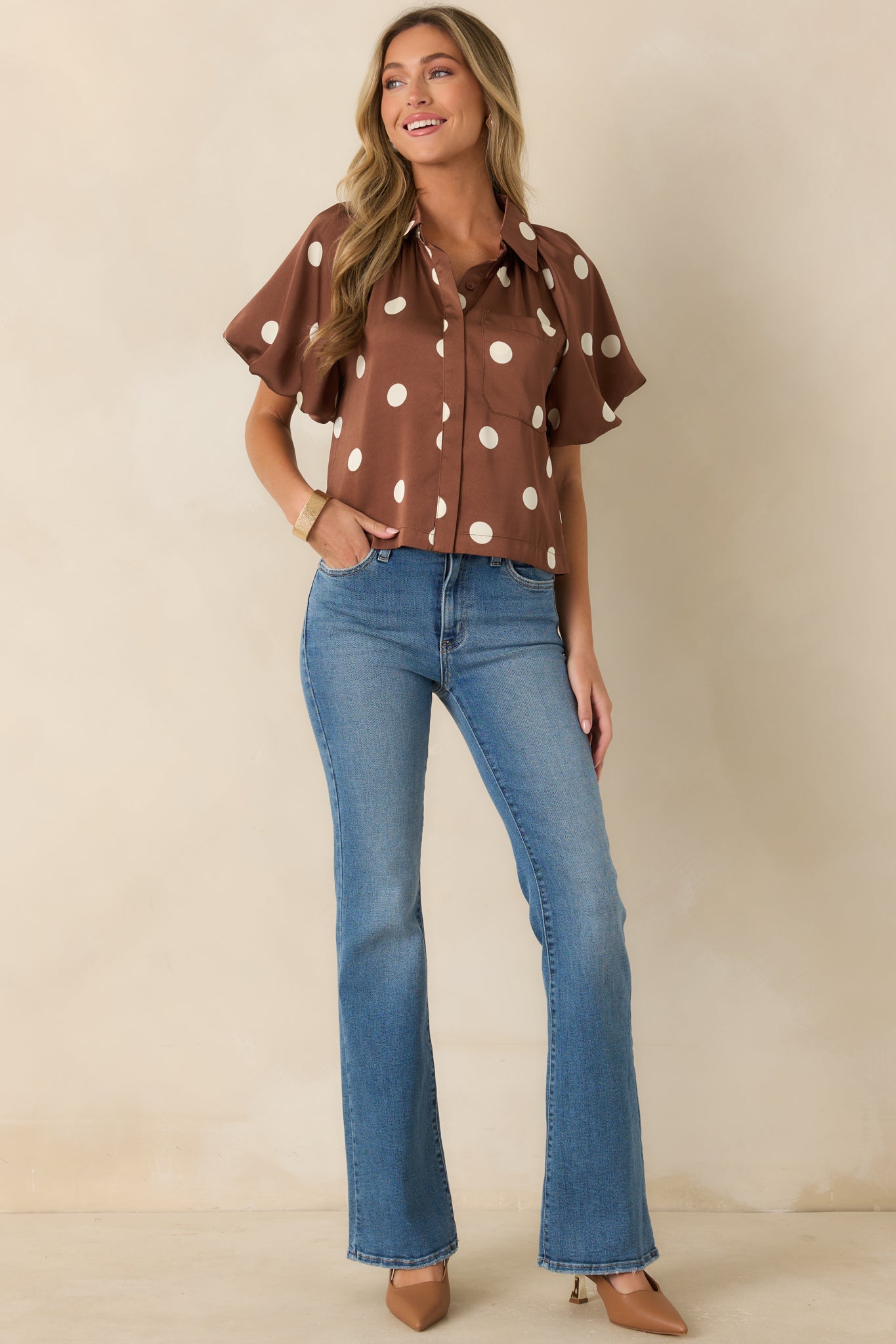 Silky finish blouse designed with voluminous puff sleeves, gathered detailing, and a refined button-front silhouette.