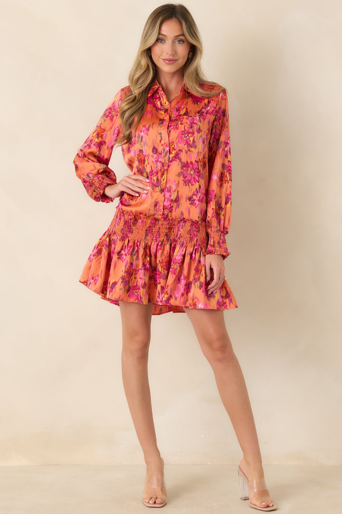 Silky collared mini dress with a full button front, billowy long sleeves, elasticized cuffs, and a gathered drop waist flowing into a playful flouncy skirt.
