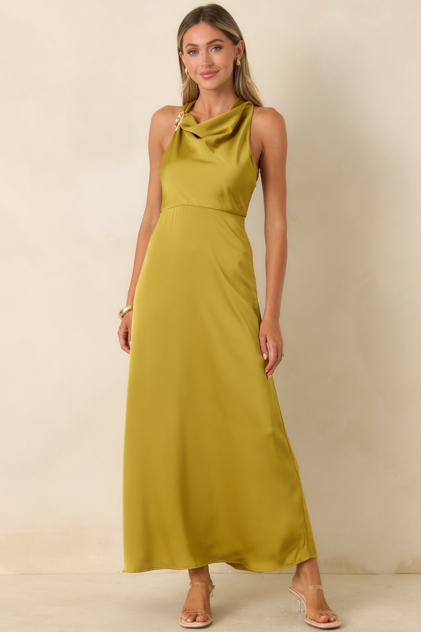 Silky satin maxi dress showcasing a sculptural gold-tone shoulder detail and a flattering A-line design.