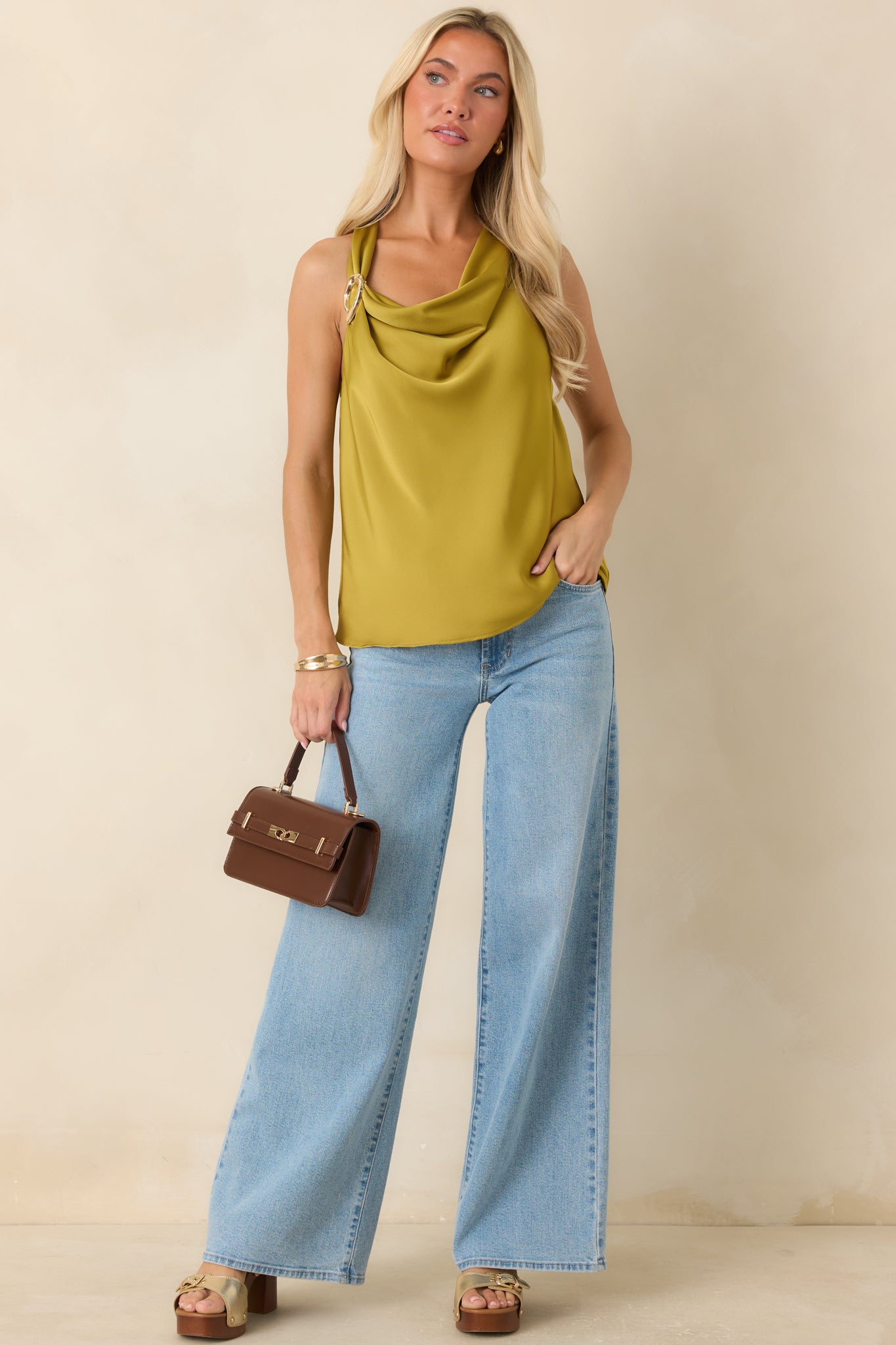 Silky satin-look top featuring a draped neckline, gold-tone shoulder accent, and relaxed sleeveless silhouette.