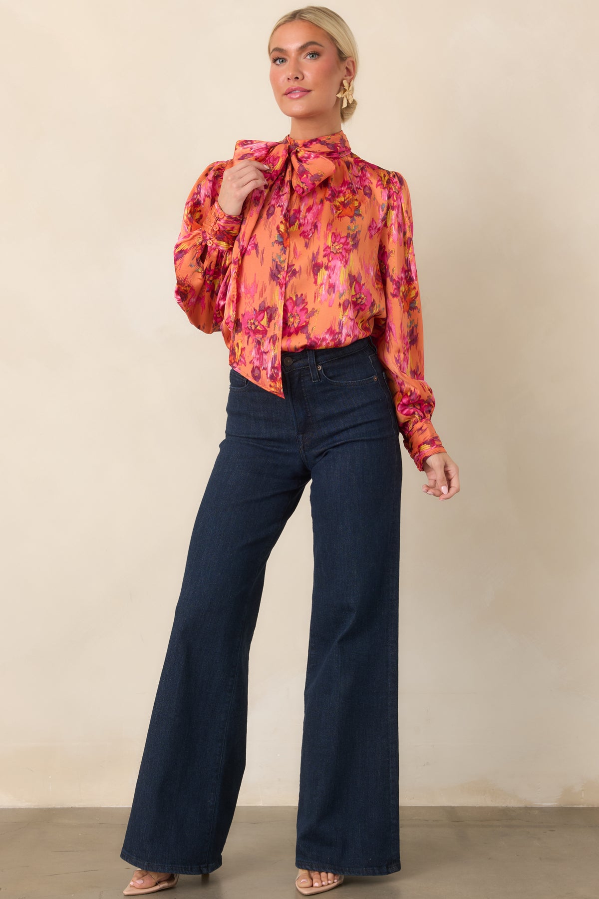 Silky satin top showcasing its bold color palette, statement tie neckline, voluminous balloon sleeves, and softly draped silhouette.