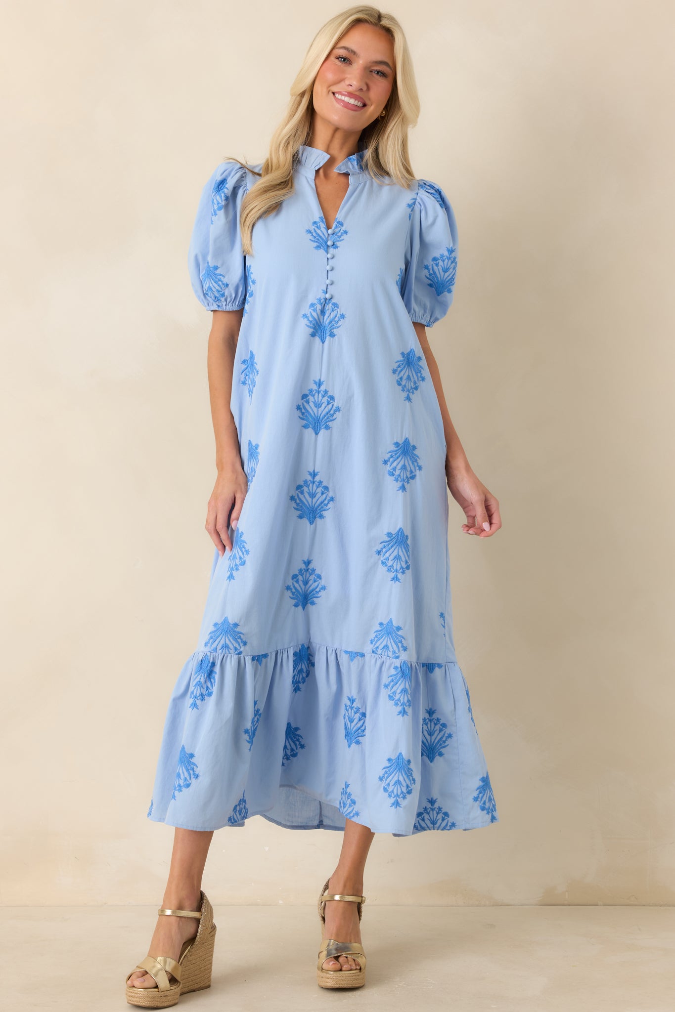 Sky blue dress showcasing delicate tonal embroidery, a relaxed silhouette, puff sleeves, and a breezy skirt finished with a soft ruffled hem.