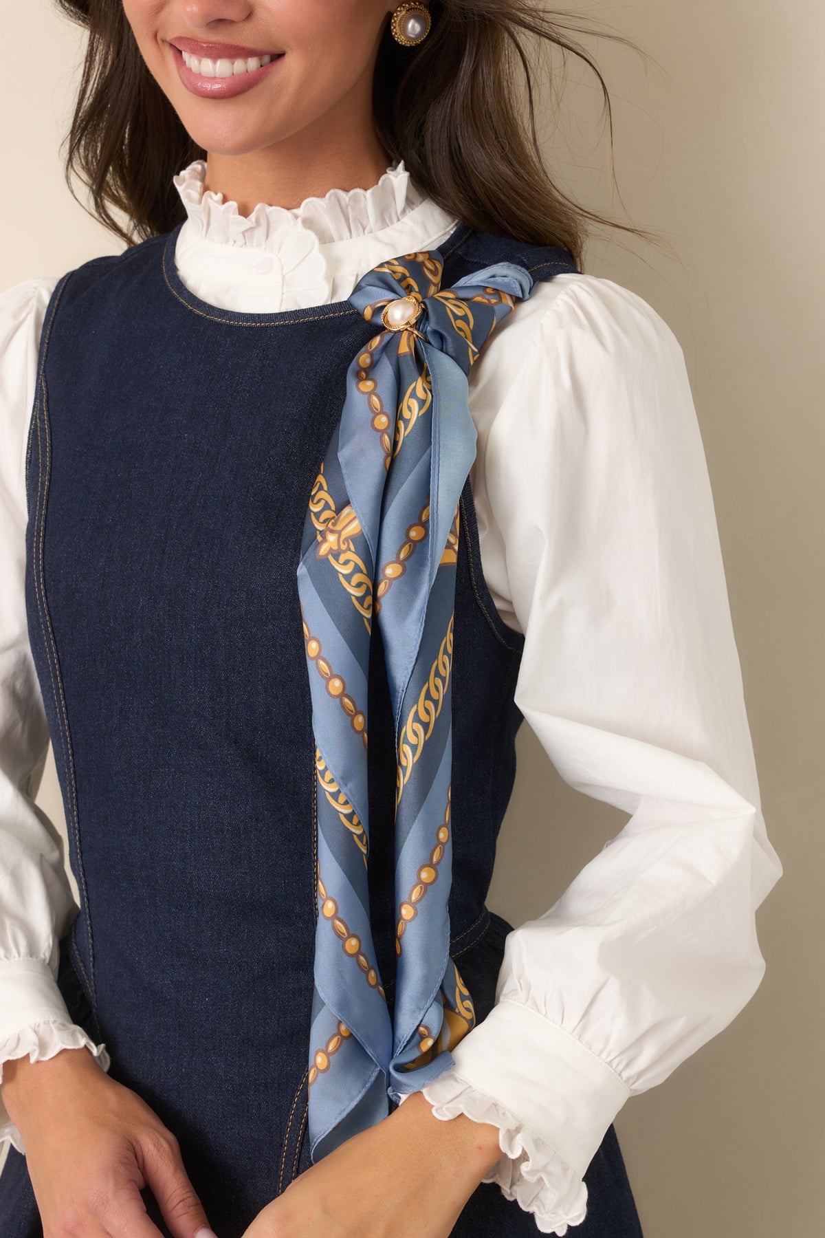 Scarf displaying ornate gold chains and decorative medallion details against slate blue.