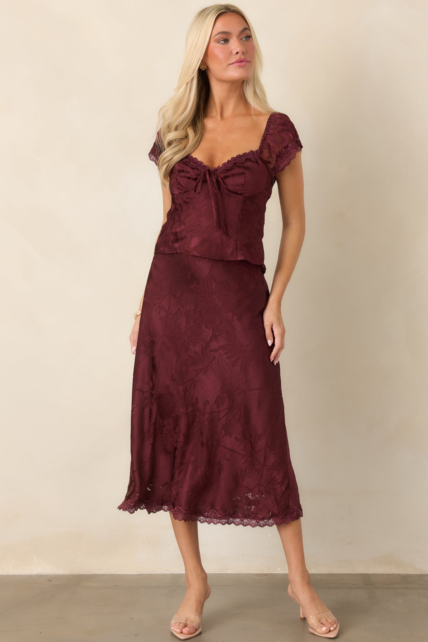 Sleek floral satin skirt with a graceful bias-cut silhouette, fluid movement, tonal botanical design, and delicate lace edging at the midi hem.