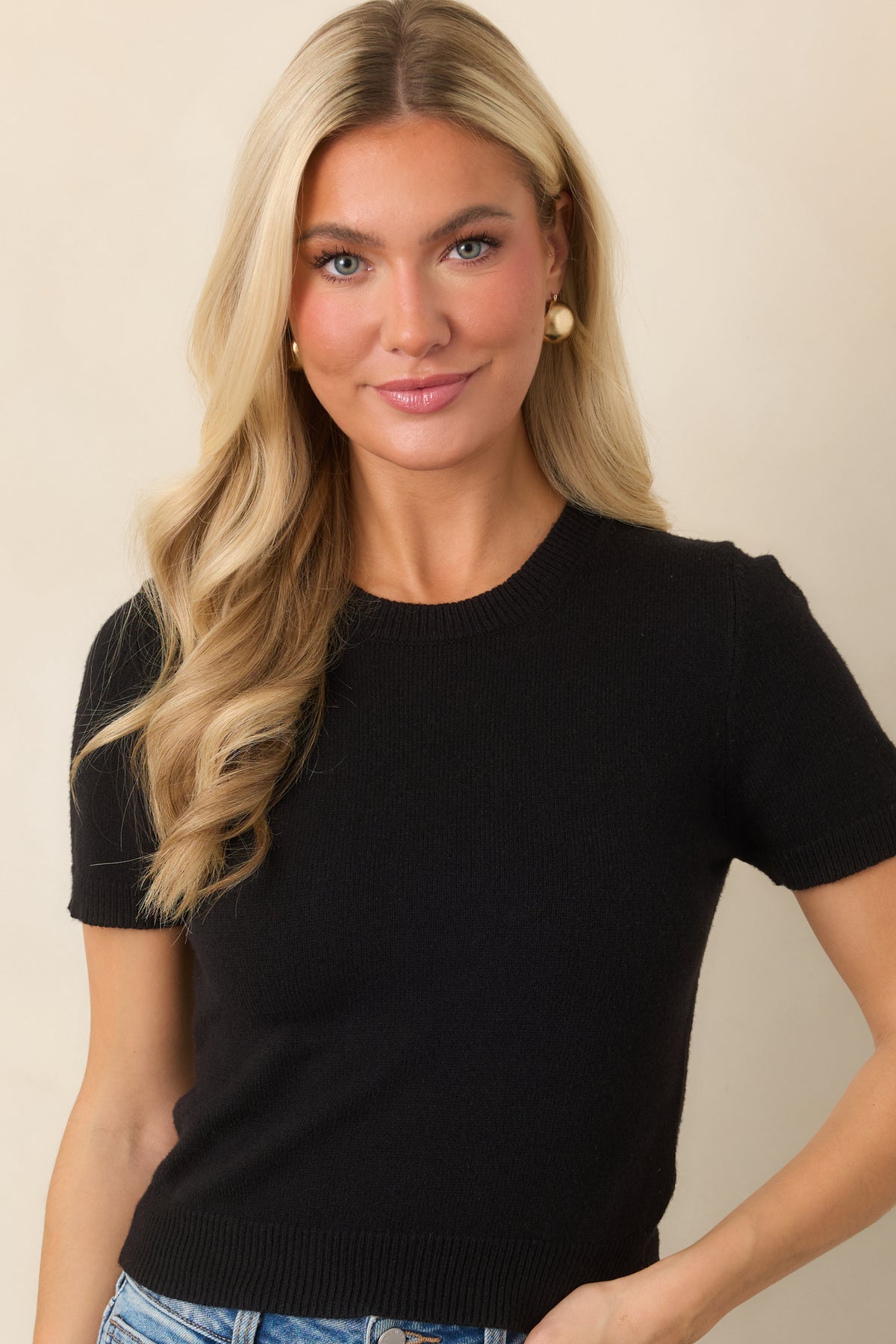 Sleek knit top featuring short sleeves and ribbed trim along the neckline and hem.