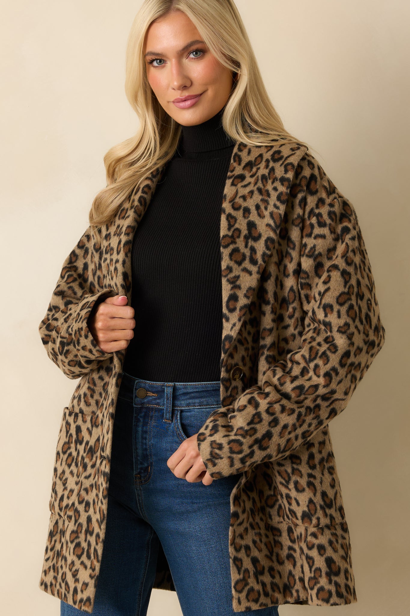 Focus on sleeve and relaxed drape of tan leopard print coat.