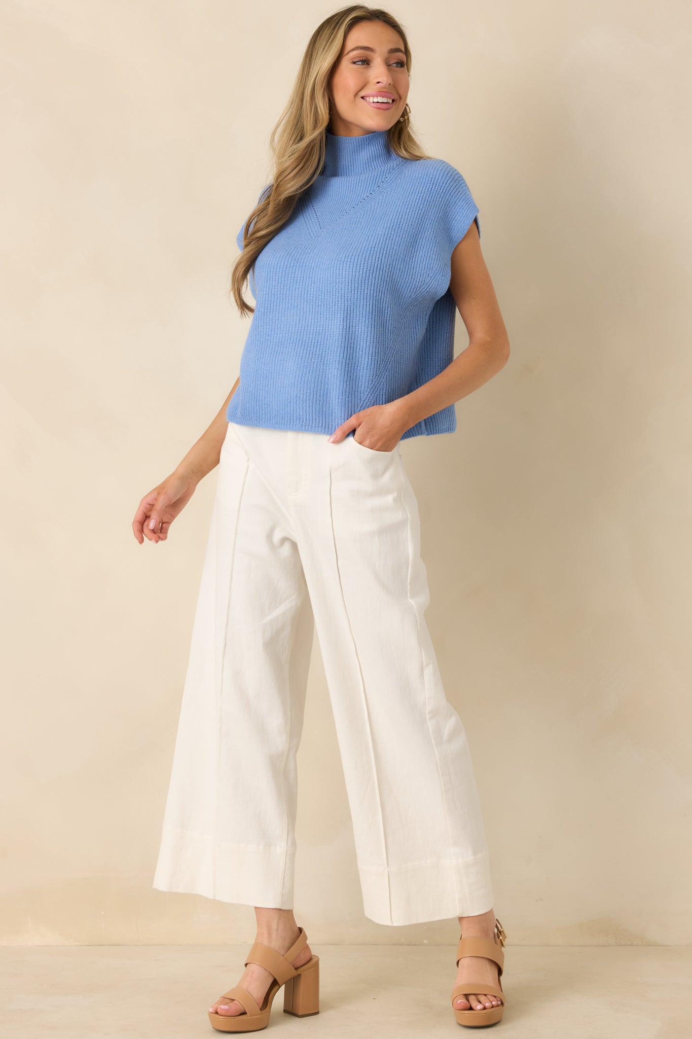 Sleeveless blue sweater top featuring subtle chest knit detail, vertical ribbing, and a longline relaxed fit for layering.