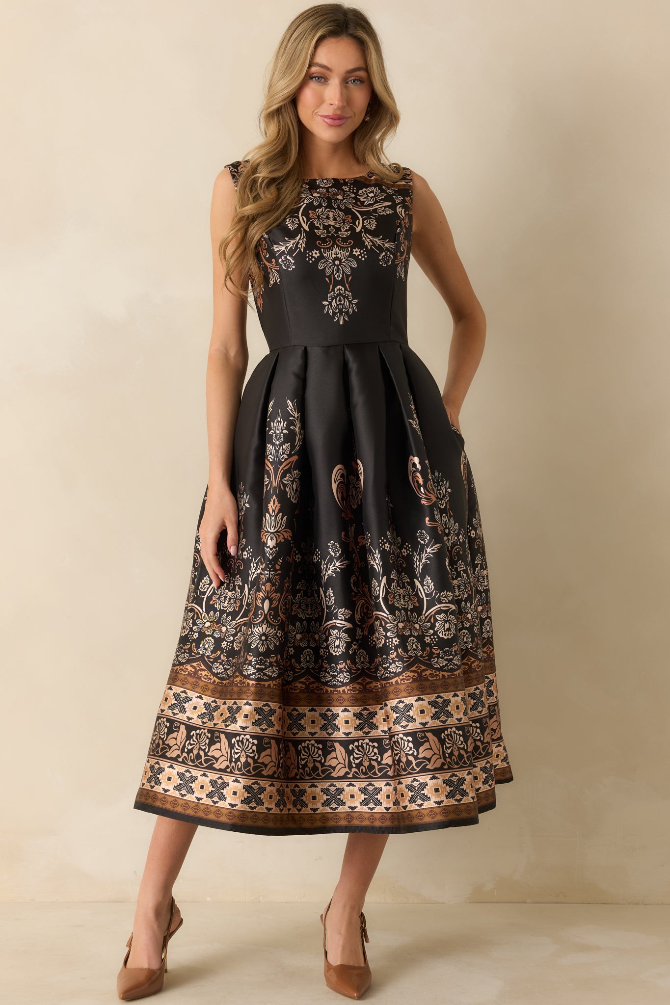 Front-facing shot emphasizing the sleeveless design and full length of the bronze-accented dress.