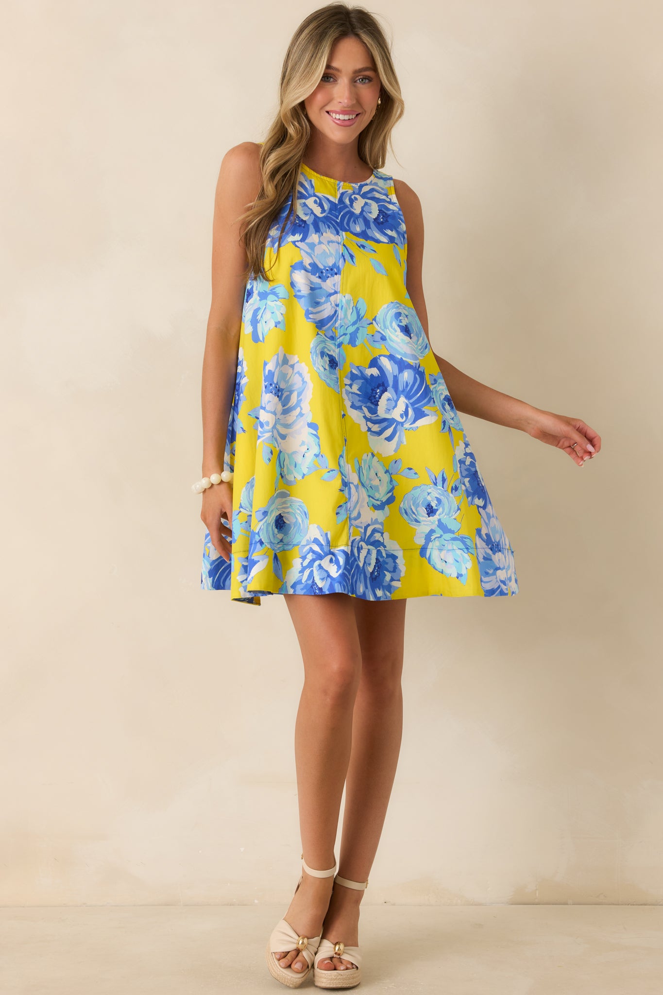 Sleeveless cotton mini dress showcasing a round neckline, hidden side pockets, and an airy relaxed fit.