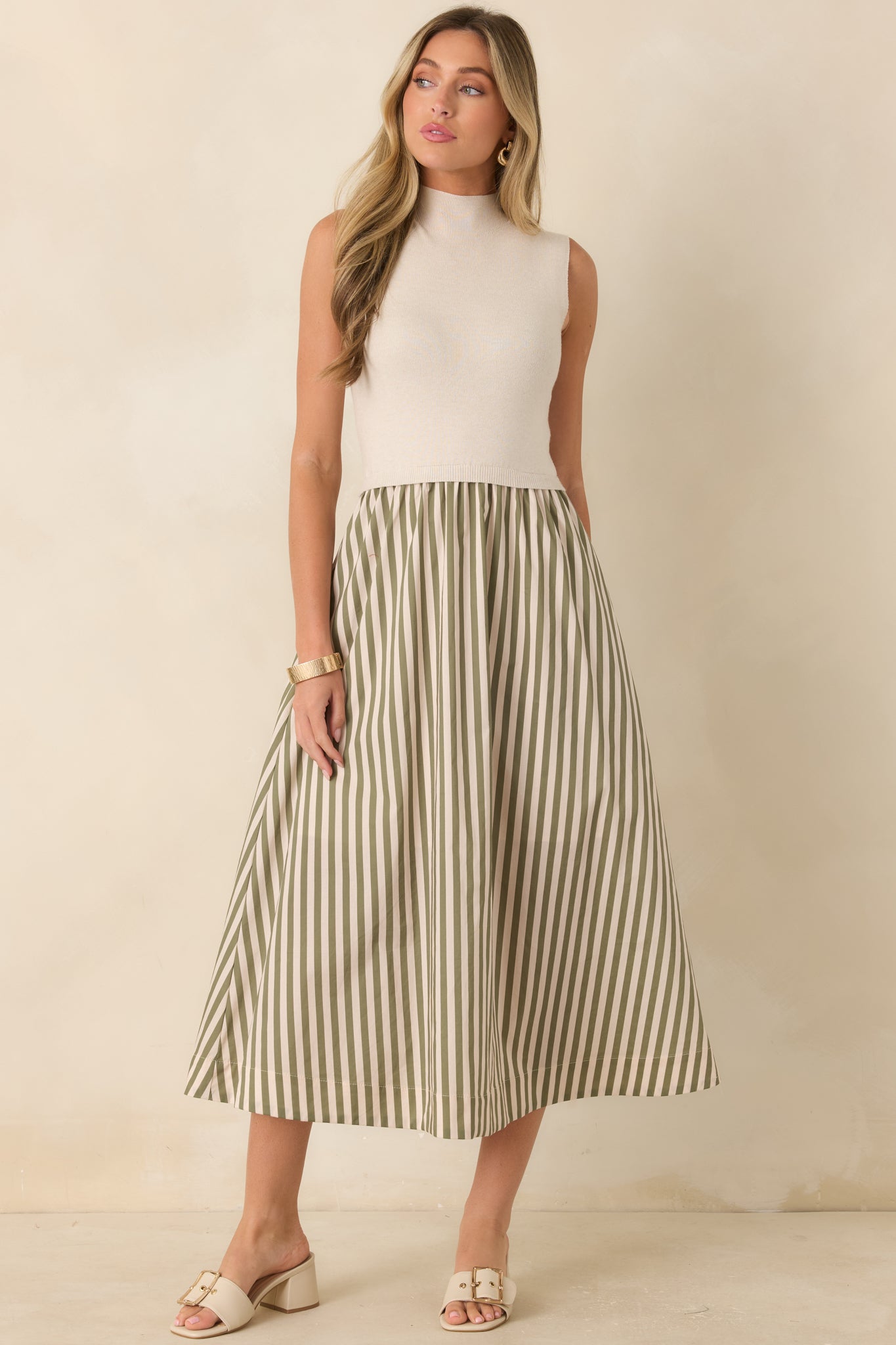 Sleeveless ecru dress showcasing a fitted upper silhouette, contrasting textures, and an elegant A-line midi skirt.