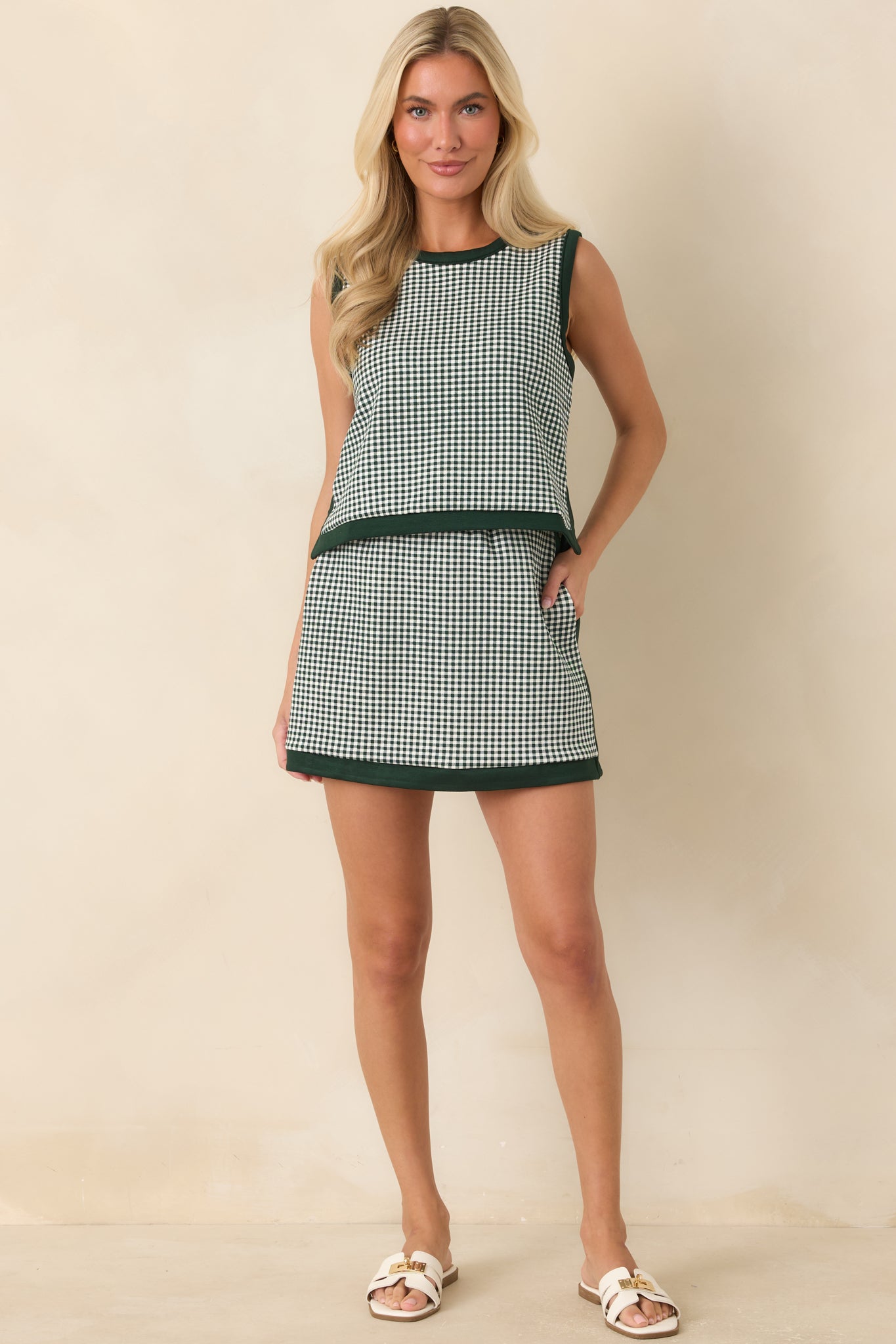 Sleeveless gingham top with a relaxed silhouette, round neckline, and distinctive button-back detail.