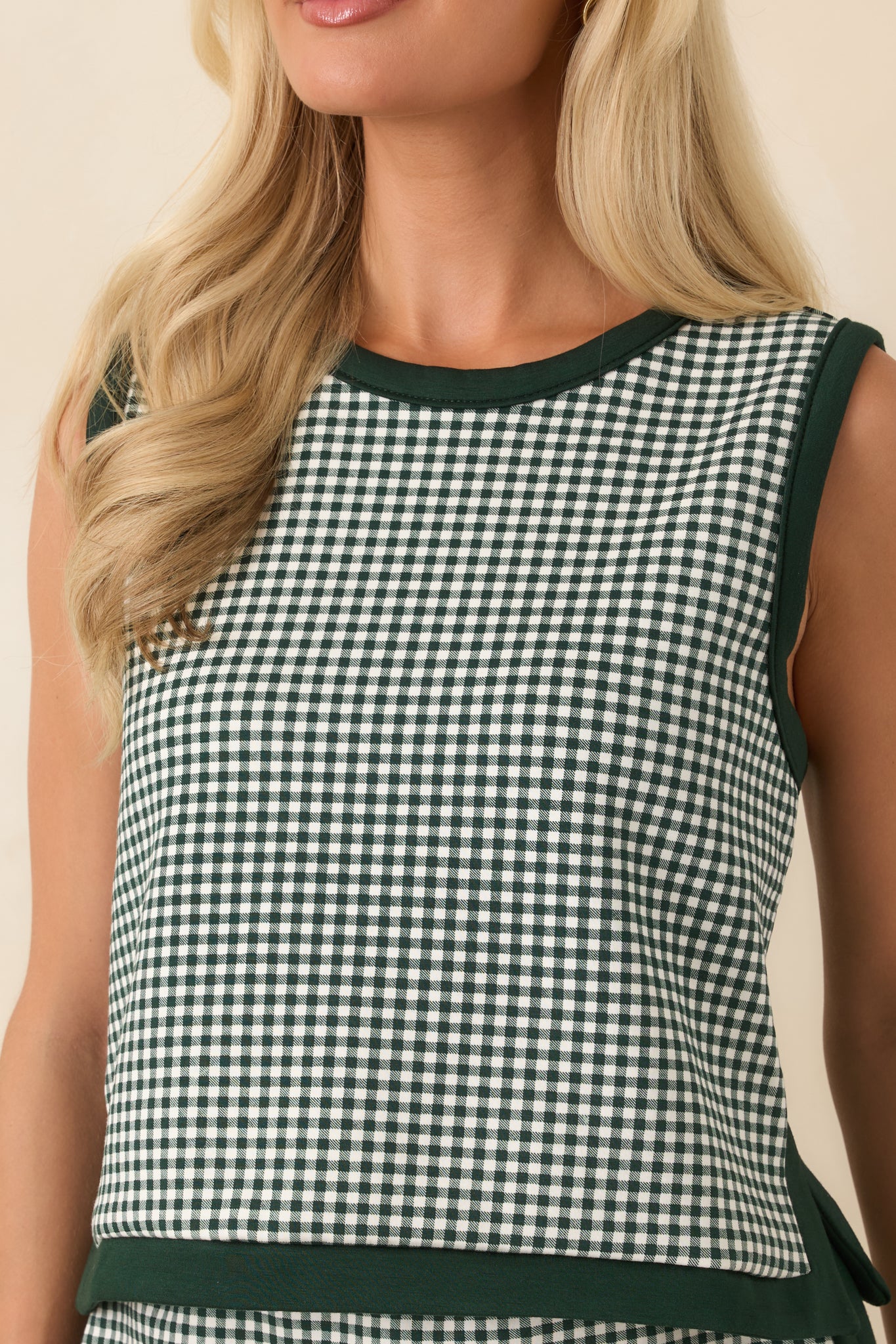 Small side slits add dimension to the cropped hem of this gingham sleeveless top.