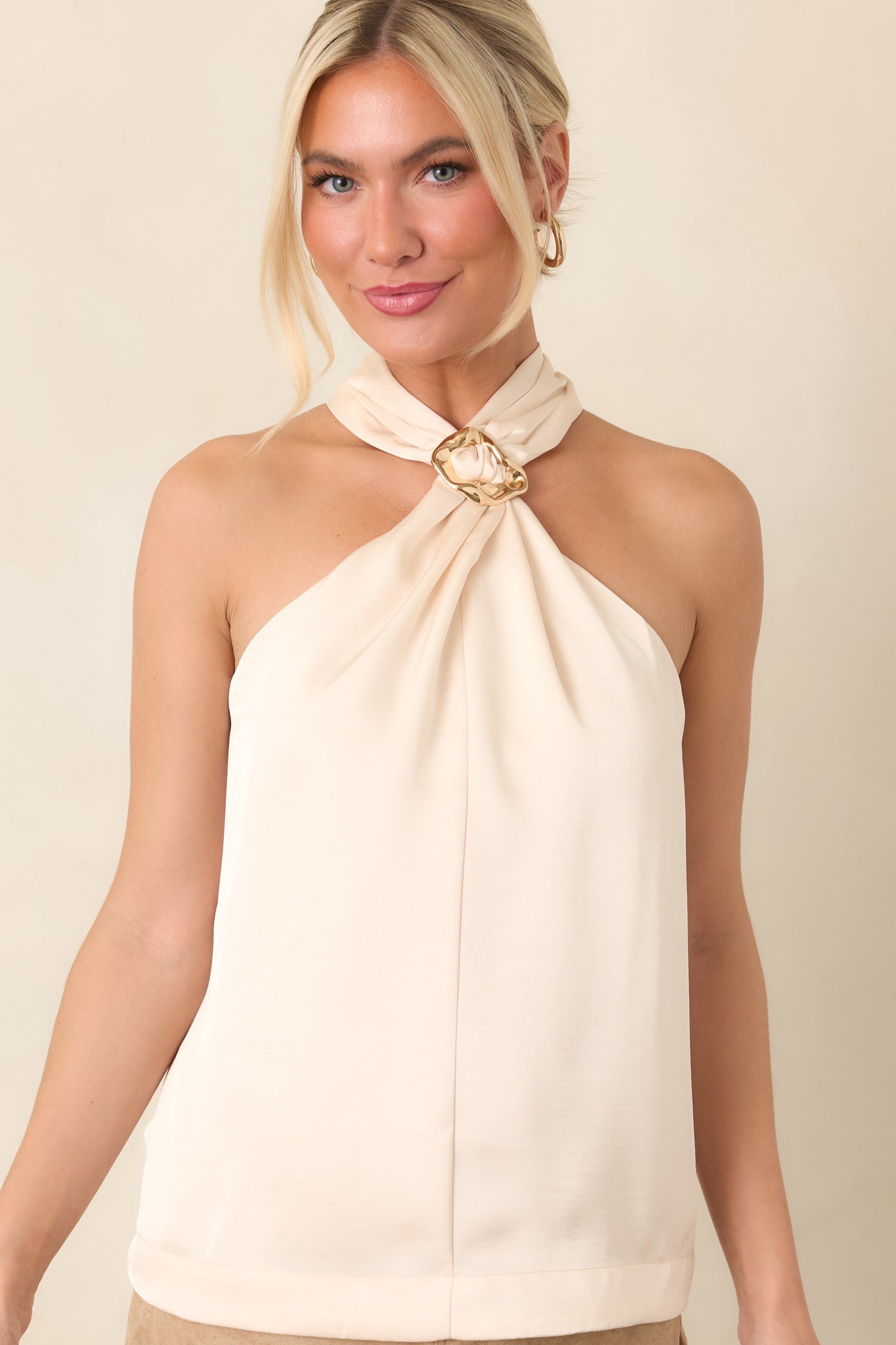 Sleeveless halter top showcasing the decorative neckline ring and softly draped front fabric.