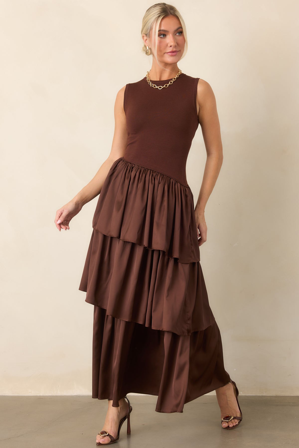 Sleeveless knit dress showcases a clean round neckline above cascading woven layers that create fluid movement.