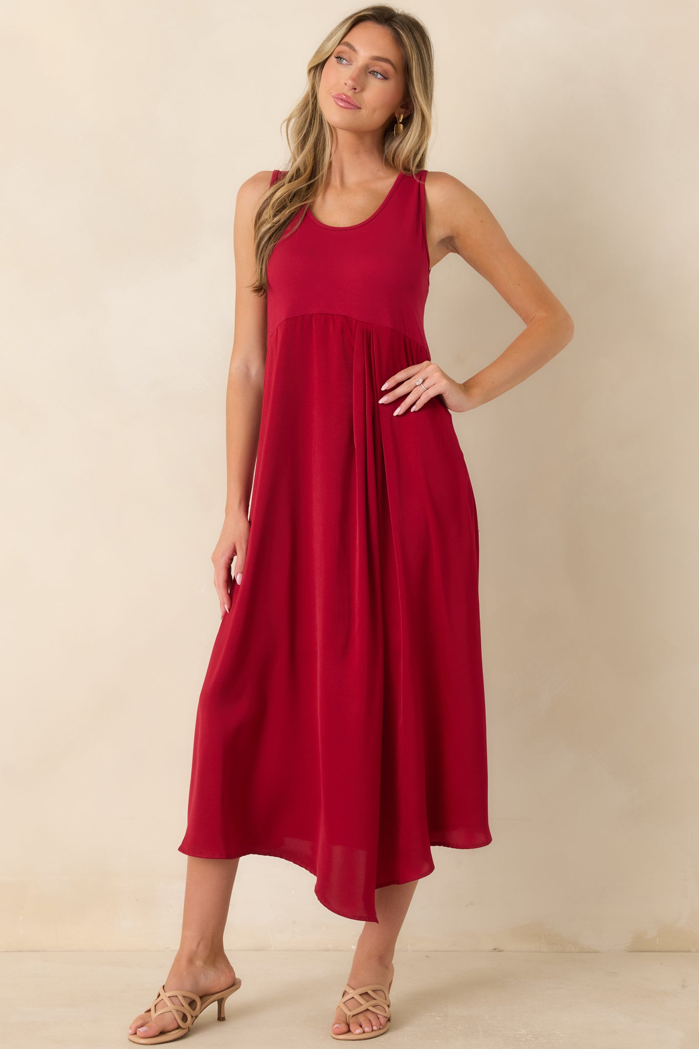 Sleeveless midi dress featuring a stretch-knit bodice, scoop neckline, and a flowing satin skirt with elegant movement.