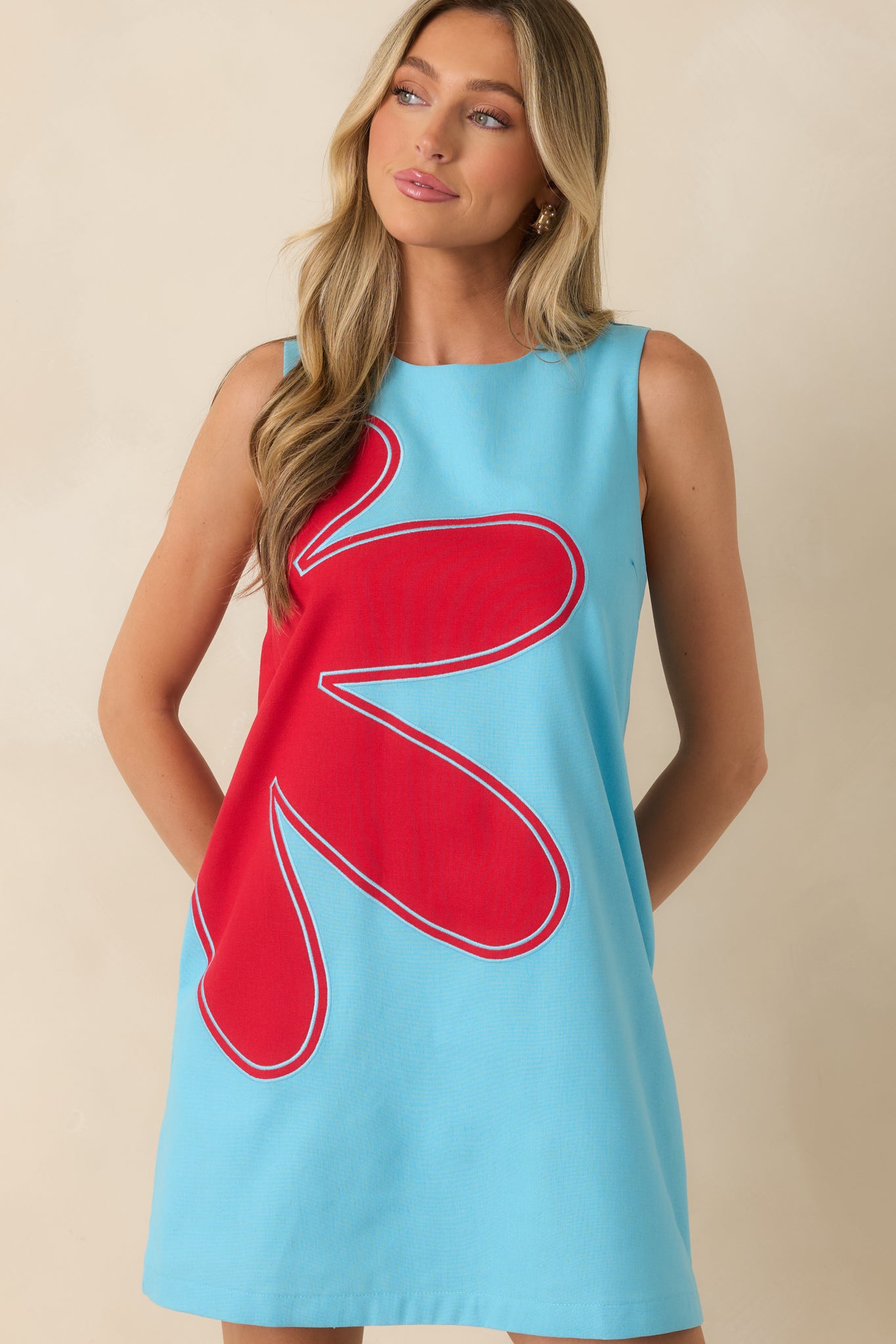 Sleeveless neckline and smooth linen blend fabric highlight the clean, modern design of this shift dress.