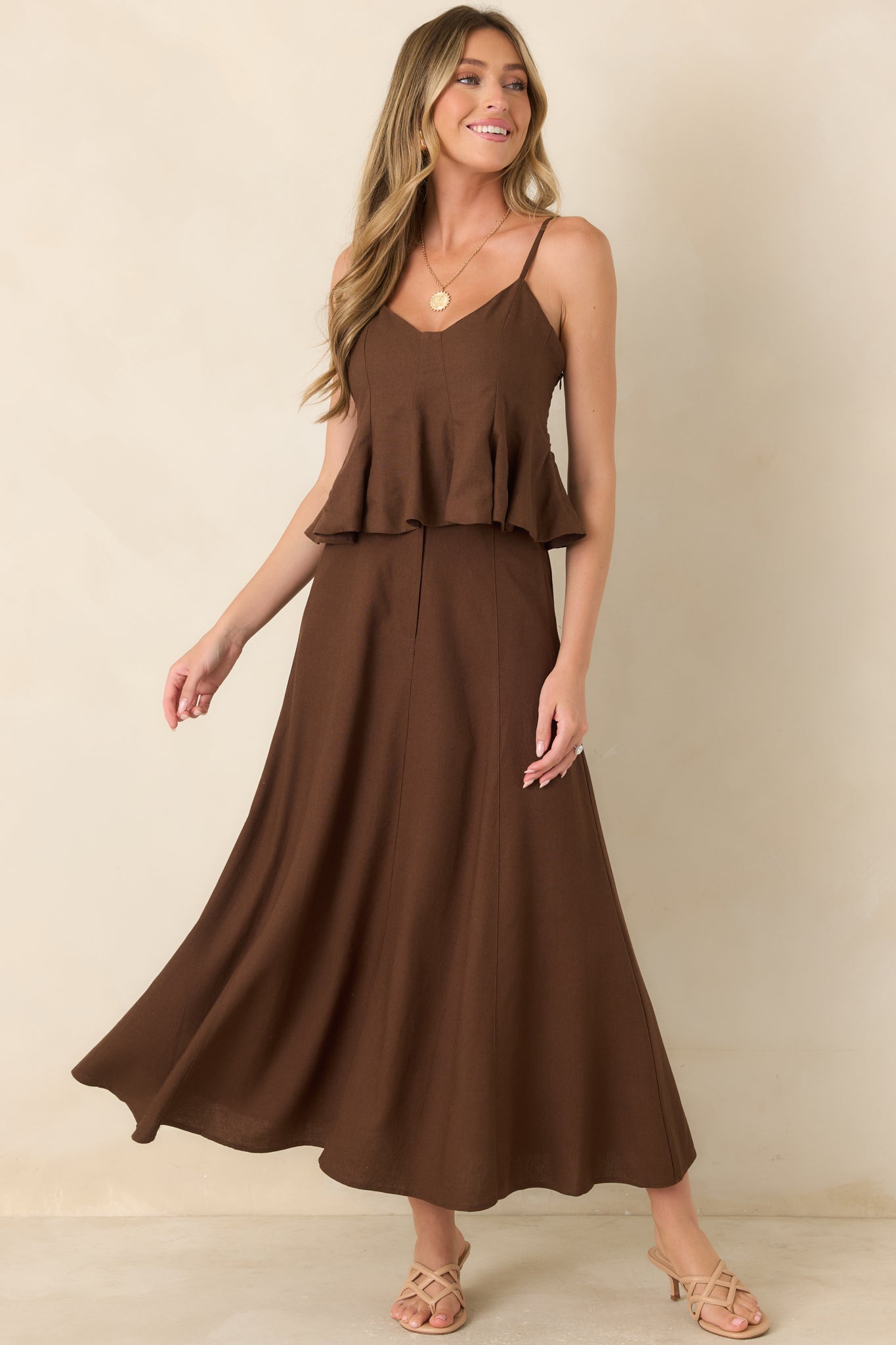 Sleeveless peplum top crafted from a linen and cotton blend, showcasing a fitted bodice with paneled construction and a graceful flared hem.