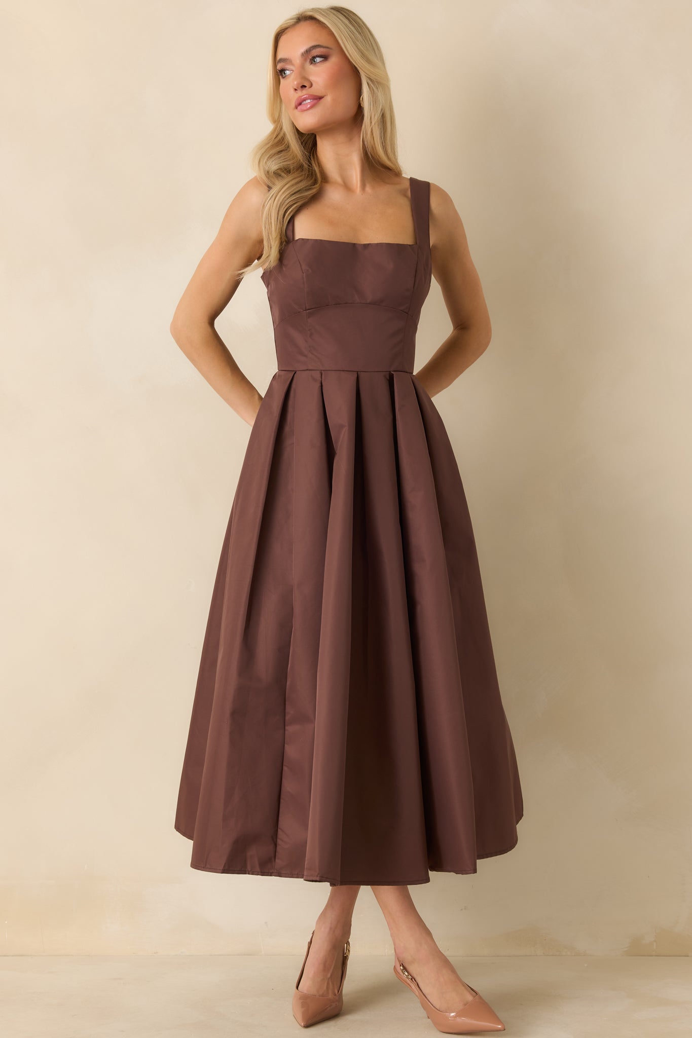 Sleeveless midi dress showing square neckline and fitted bodice with pleated skirt.