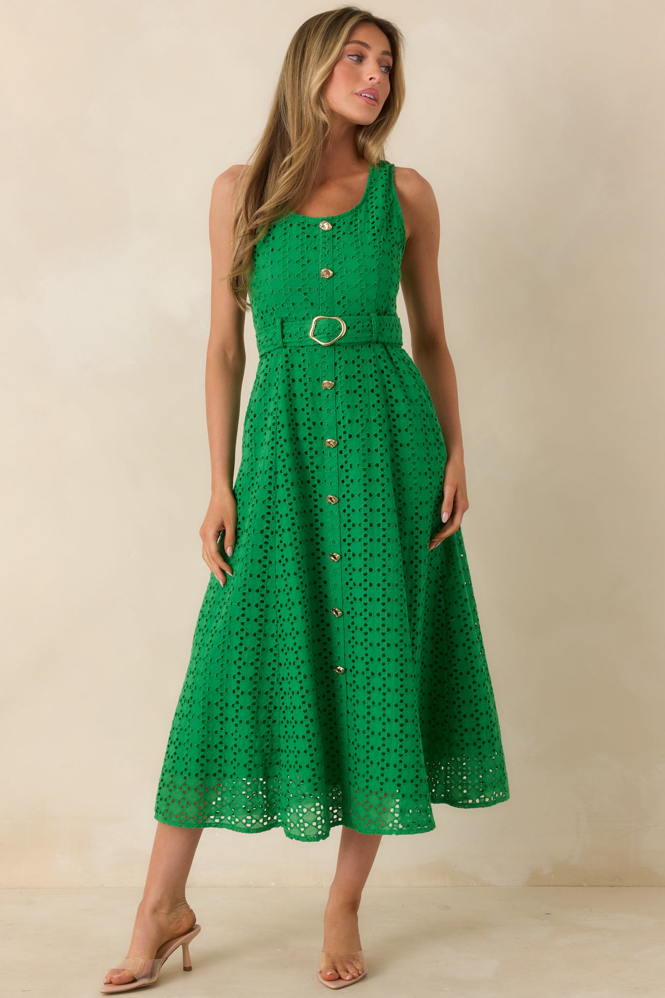 Sleeveless midi dress with intricate eyelet texture and defined waist belt.