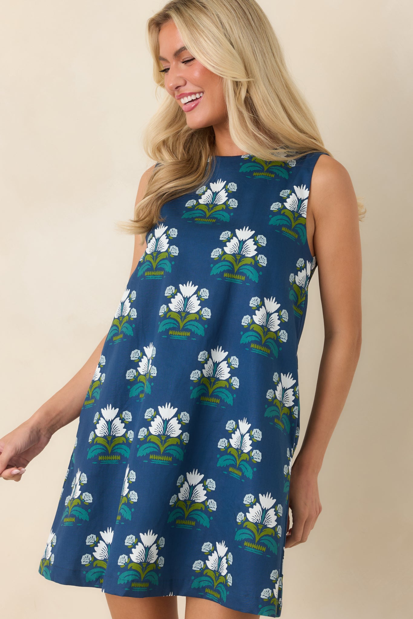 Sleeveless shift styling creates a relaxed silhouette on this deep blue cotton dress.