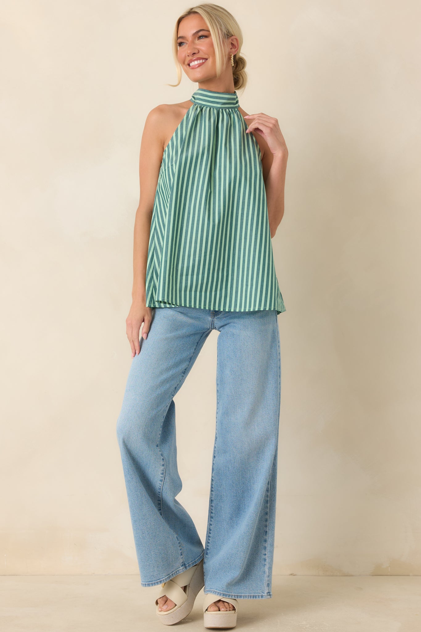 Sleeveless striped cotton top designed with a high halter neckline, soft gathers, and a breezy silhouette that drapes comfortably.